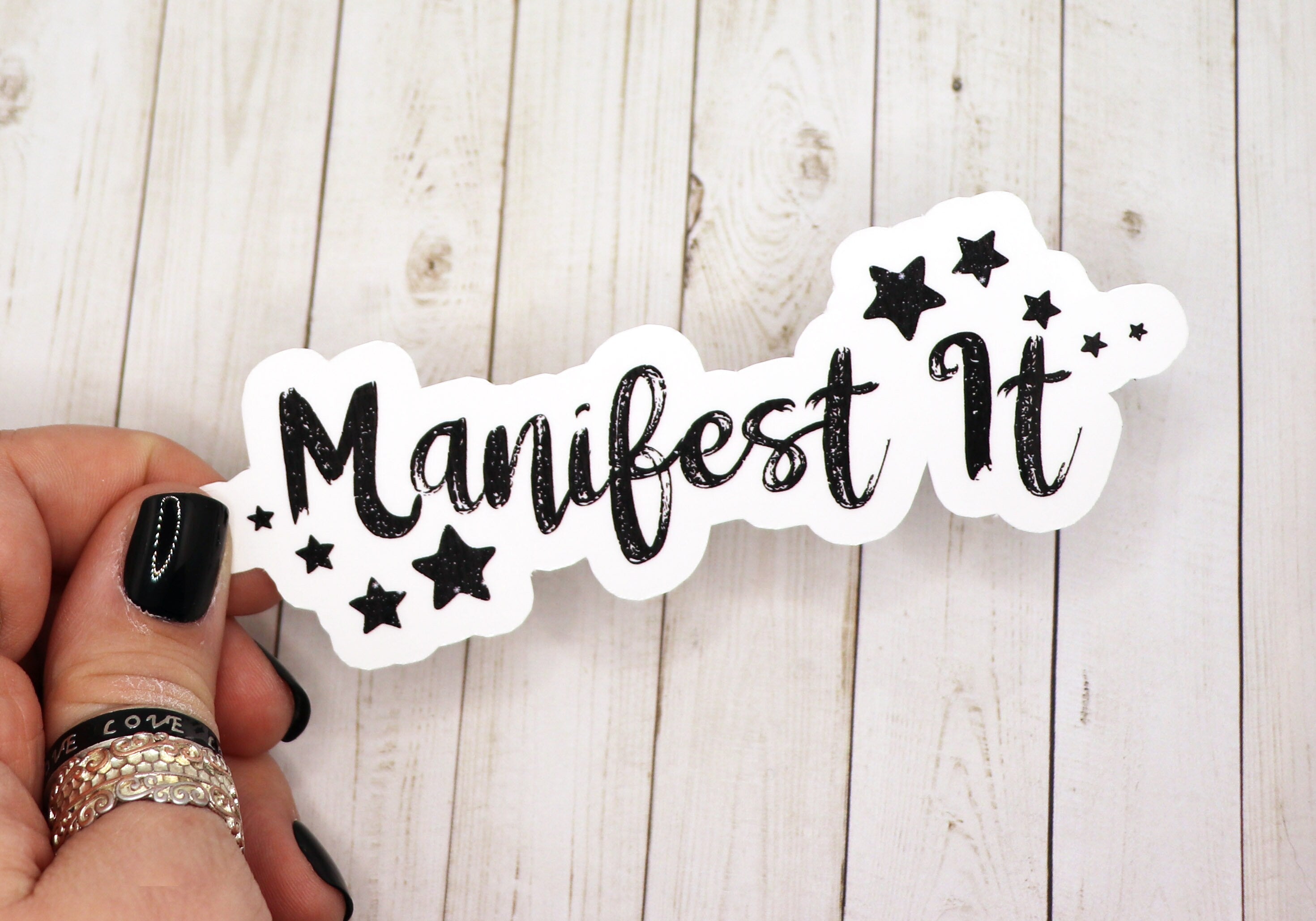 A vibrant 3.5-inch Manifest It Sticker on a white background, showcasing its motivational design and high-quality matte finish.