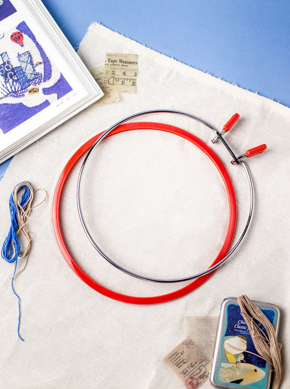 Nurge Medium Spring Metal Embroidery Hoop in Deep Red, showcasing its sleek design and spring tension mechanism.