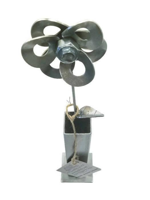 Handcrafted metal flower made from recycled steel, displayed in a matching steel vase, showcasing unique design and craftsmanship.