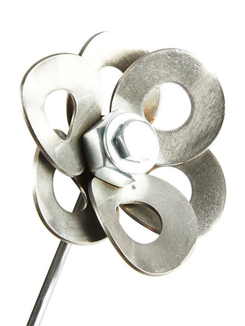 Handcrafted metal flower made from recycled steel, displayed in a matching steel vase, showcasing unique design and craftsmanship.
