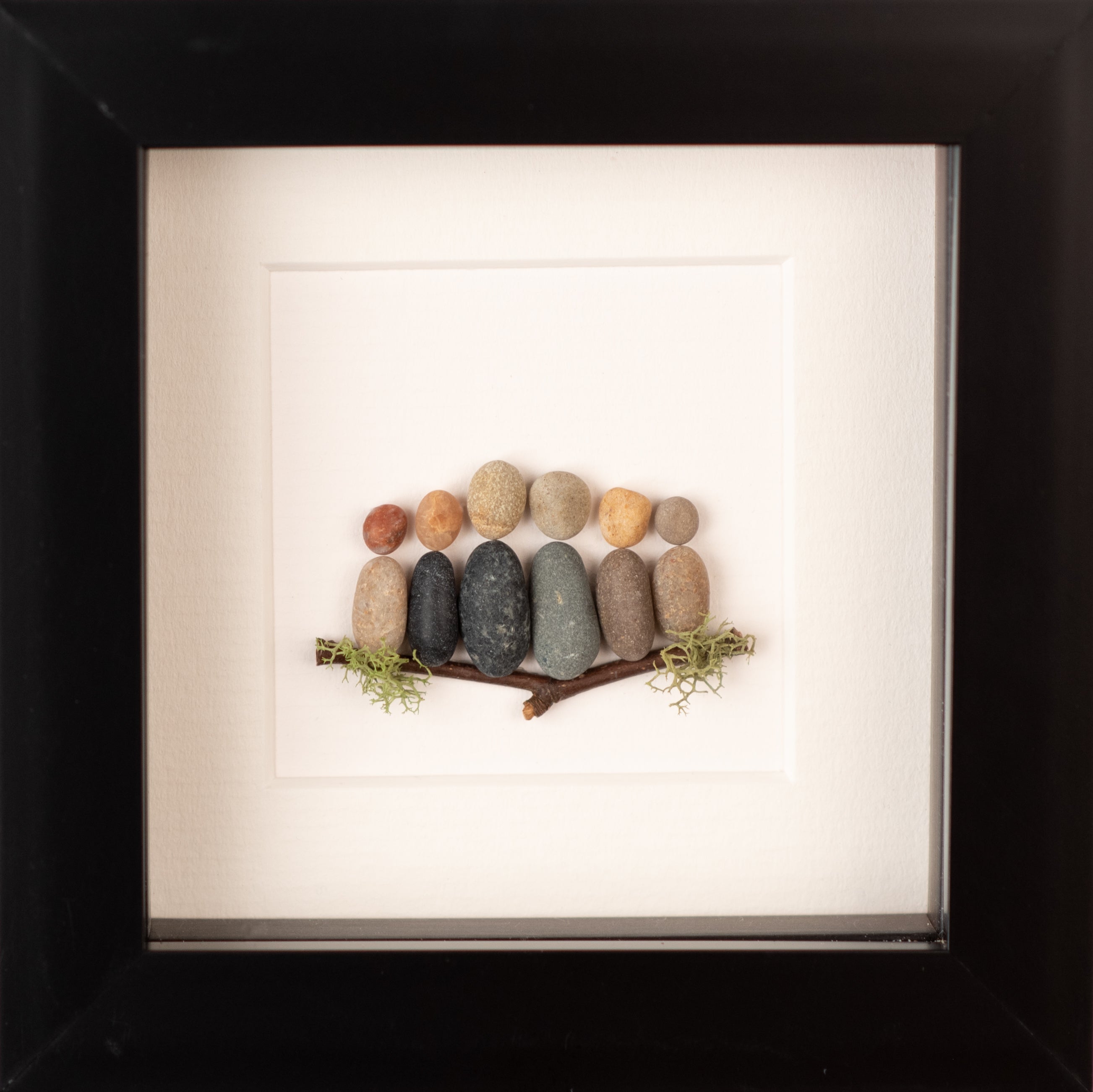 A beautifully crafted Mini Family artwork framed in white, showcasing unique natural materials representing family bonds.