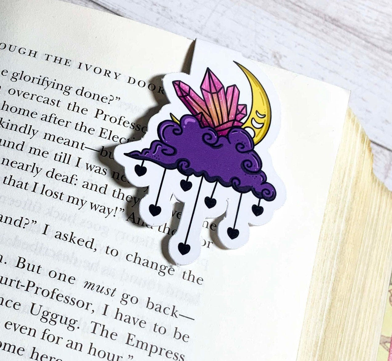 A beautifully designed Moon and Cloud Bookmark featuring celestial artwork, double-sided, scratch-resistant, and splash-resistant with strong magnets.