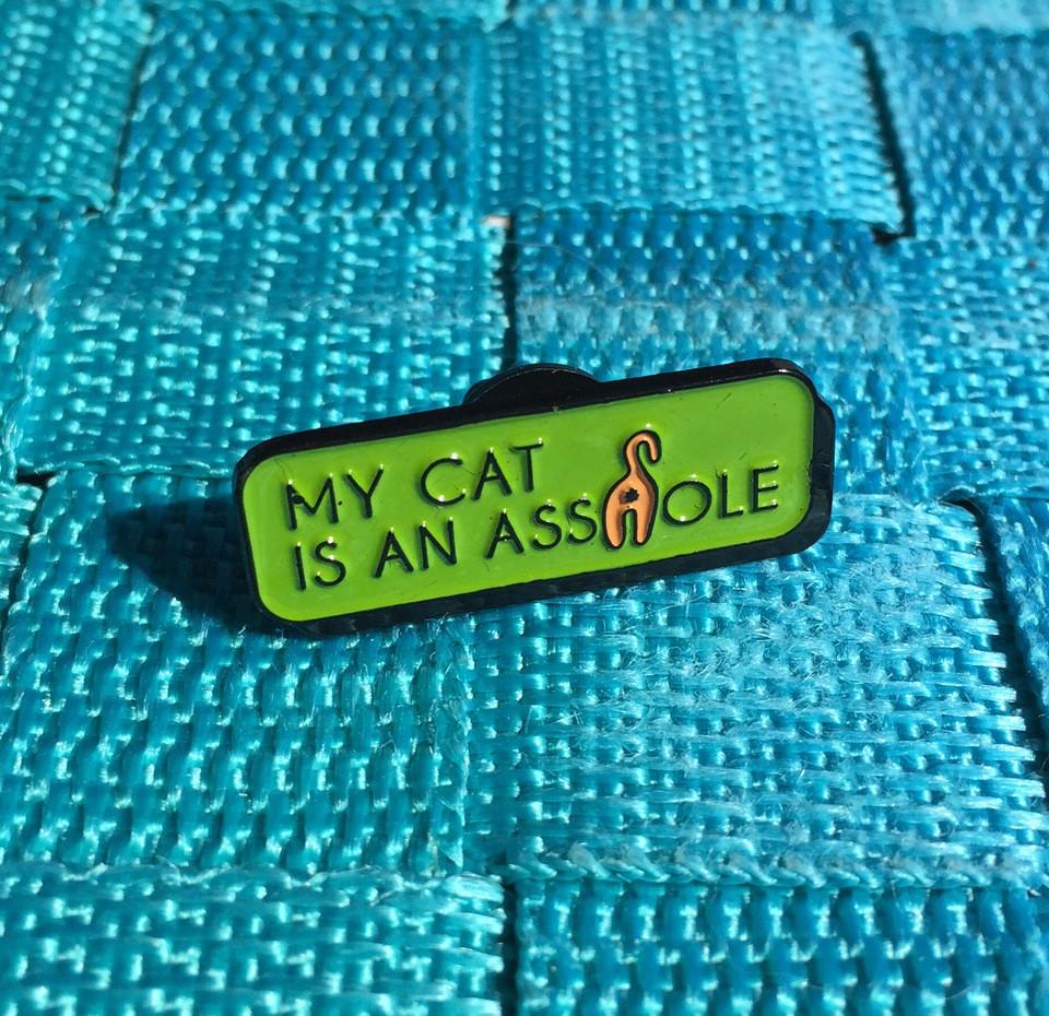 My Cat is an A**hole Soft Enamel Pin featuring a playful cat butt design in vibrant colors, measuring 1.25 inches.