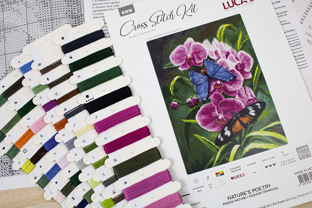 Nature's Poetry B7010L Counted Cross-Stitch Kit with Aida canvas, needle, and colorful threads displayed on a table.