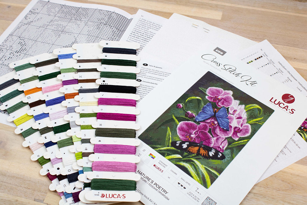 Nature's Poetry B7010L Counted Cross-Stitch Kit with Aida canvas, needle, and colorful threads displayed on a table.