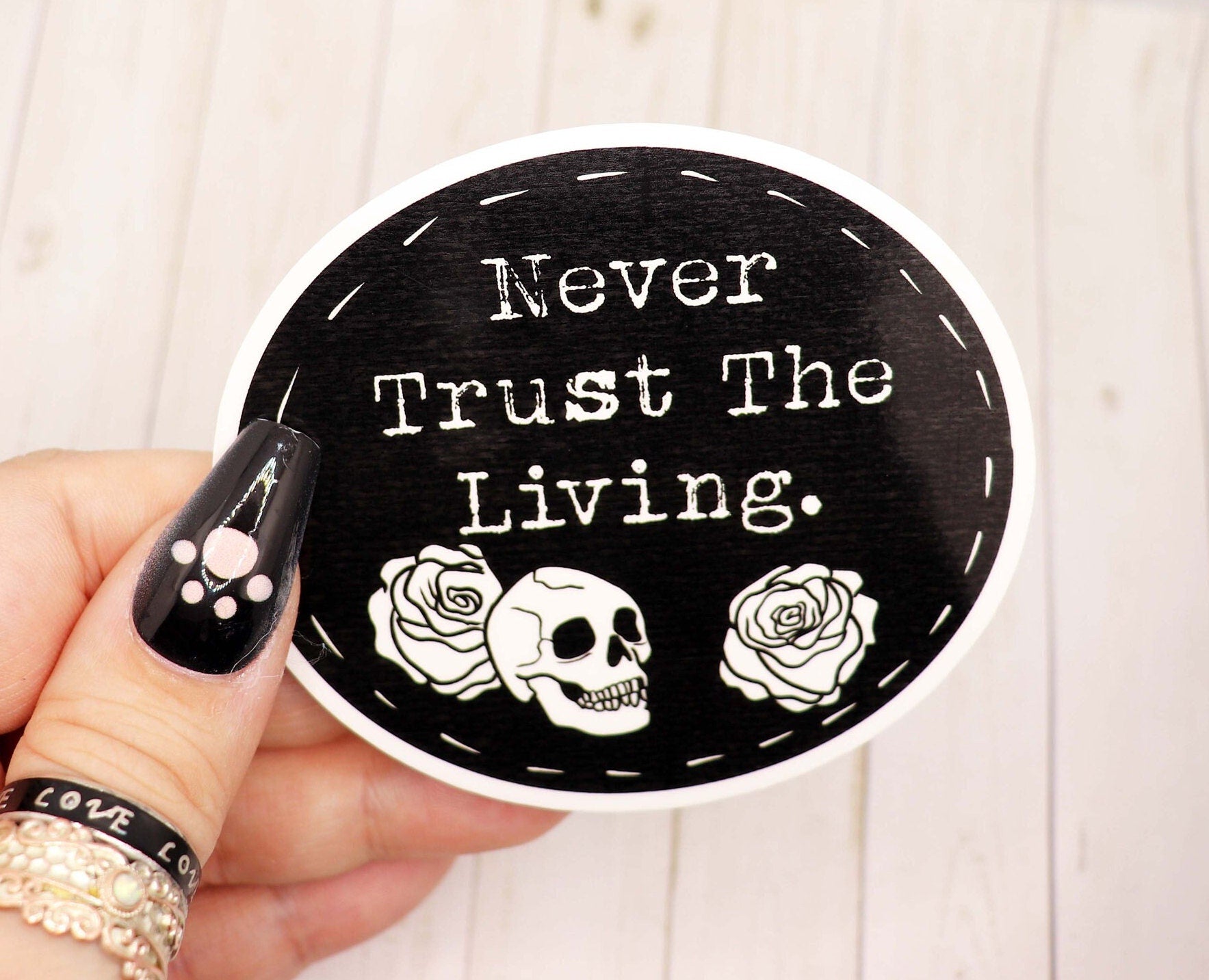 Never Trust the Living vinyl sticker featuring a unique design, measuring 2.5 inches, perfect for personalizing various items.