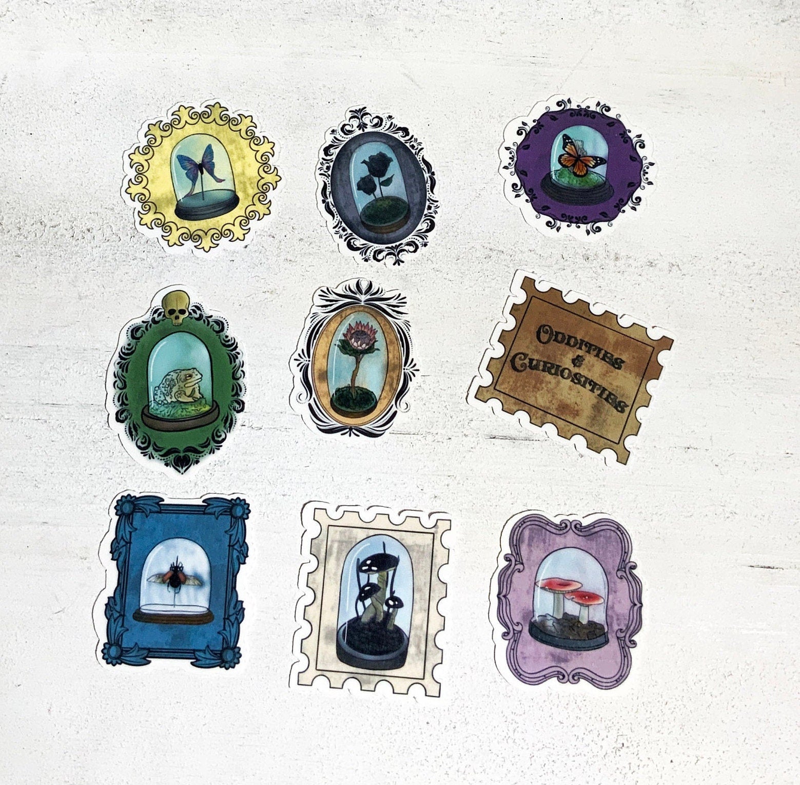 A collection of 9 unique oddity and curiosity stamp stickers, showcasing vibrant designs on high-quality matte vinyl.