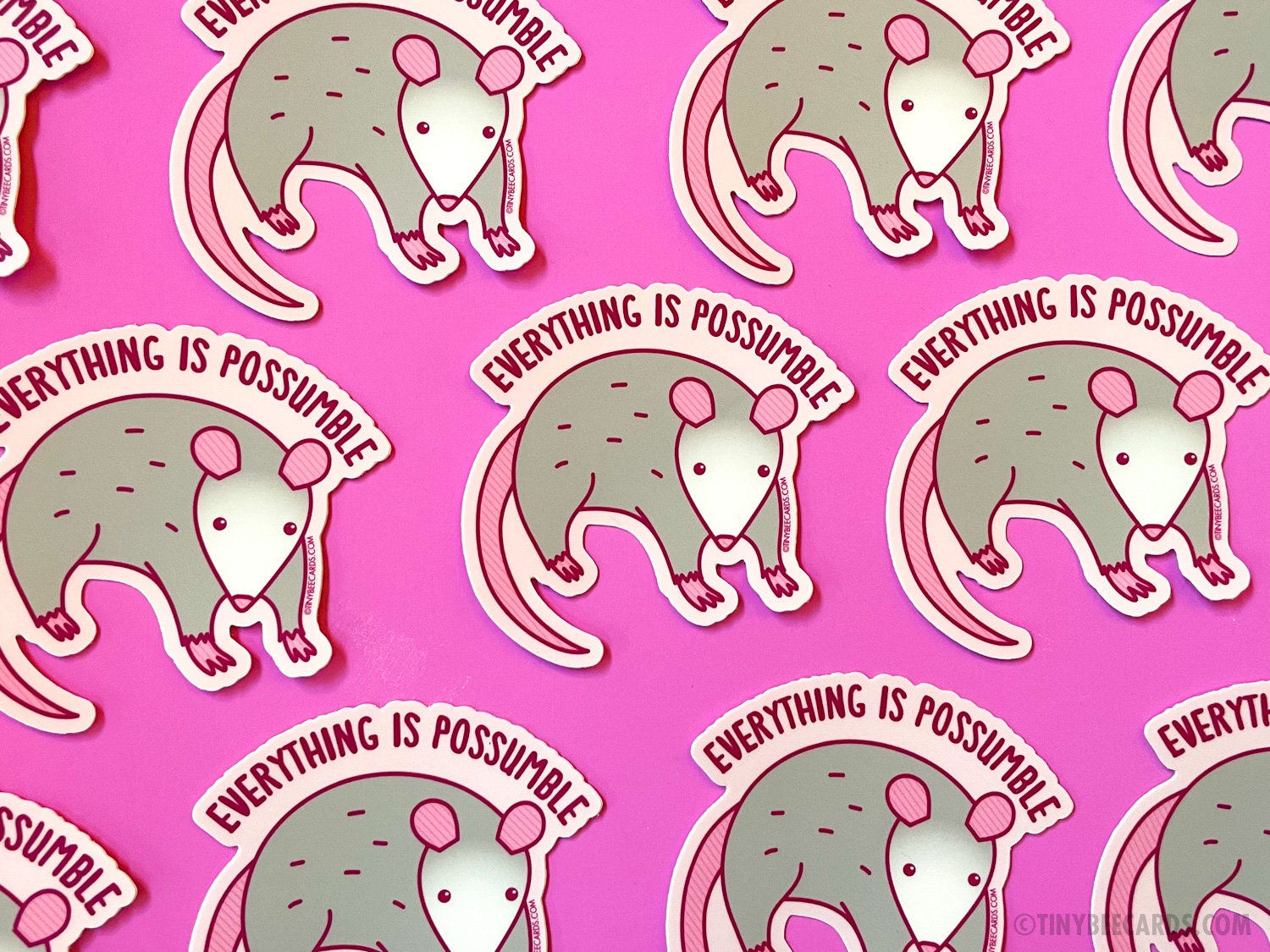 A cute opossum vinyl sticker with the text 'Everything is Possumble!' showcasing a whimsical design perfect for decoration.