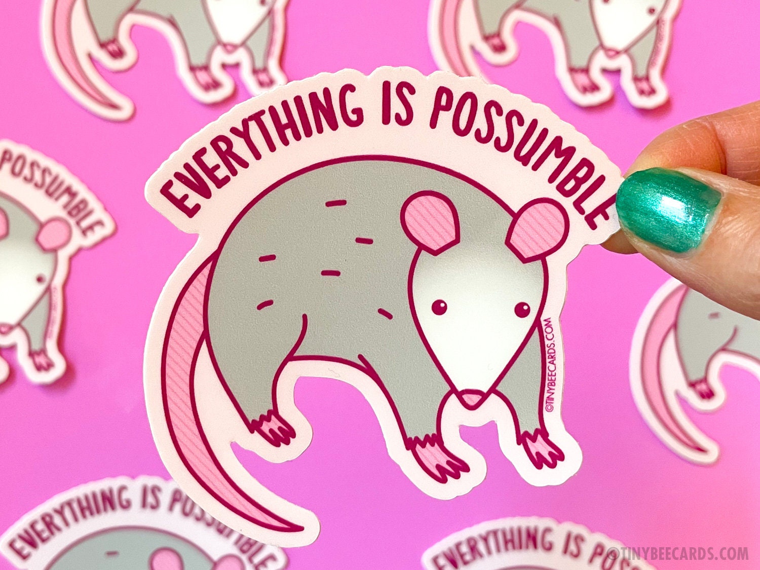 A cute opossum vinyl sticker with the text 'Everything is Possumble!' showcasing a whimsical design perfect for decoration.