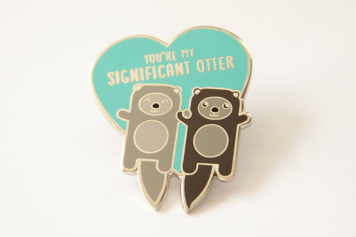 Otters Holding Hands Hard Enamel Pin featuring two otters with the text 'You're My Significant Otter' in a playful design.