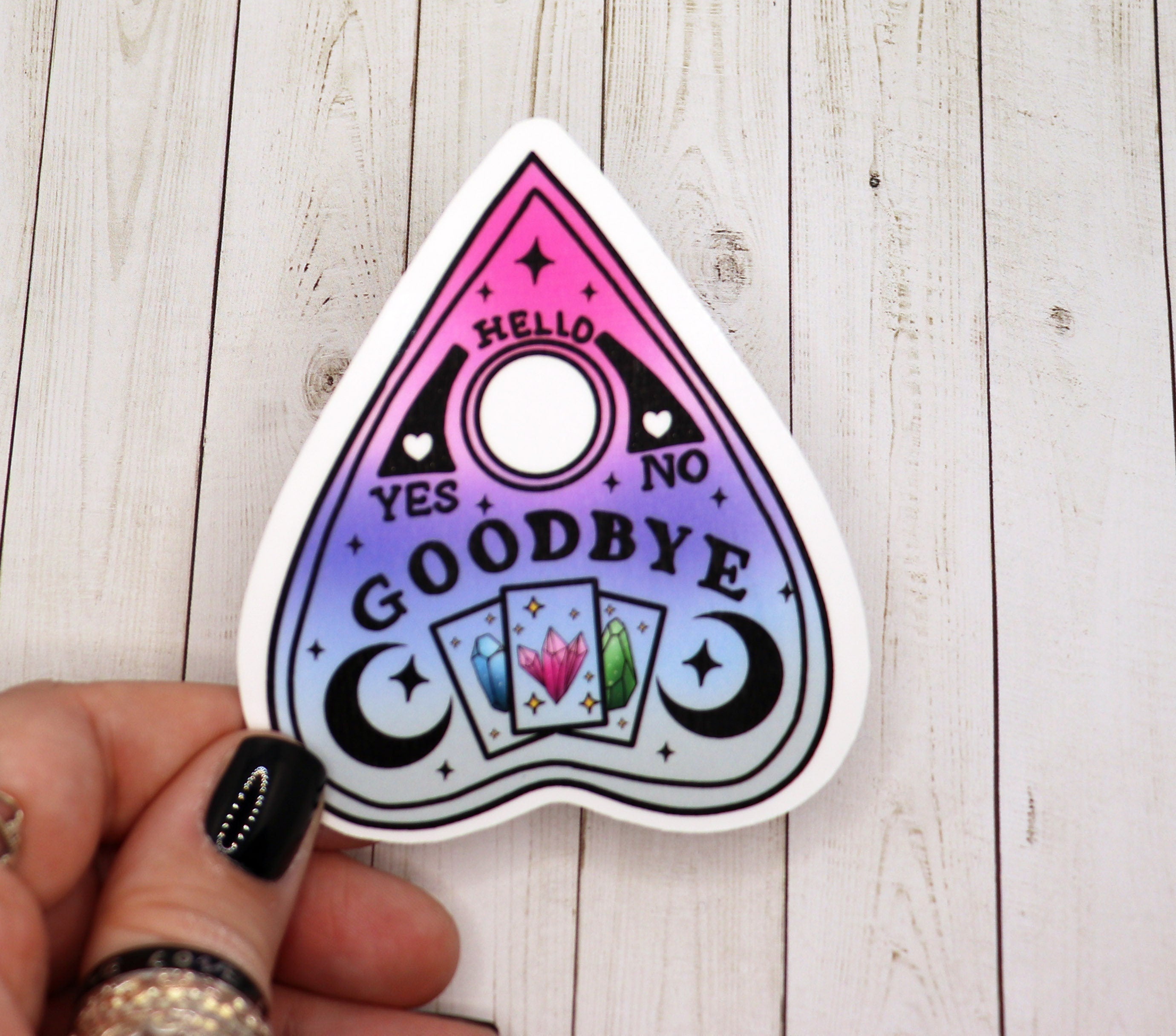 A 3-inch Ouija board planchette sticker on a matte vinyl surface, featuring intricate mystical designs.