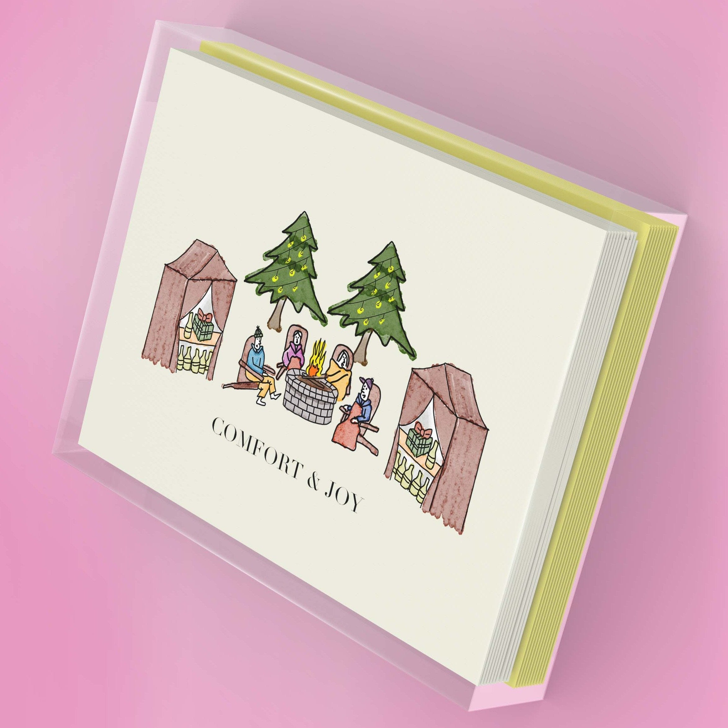 Outdoor Christmas greeting card set featuring a hand-drawn campfire scene with four people, packaged in a clear plastic box.