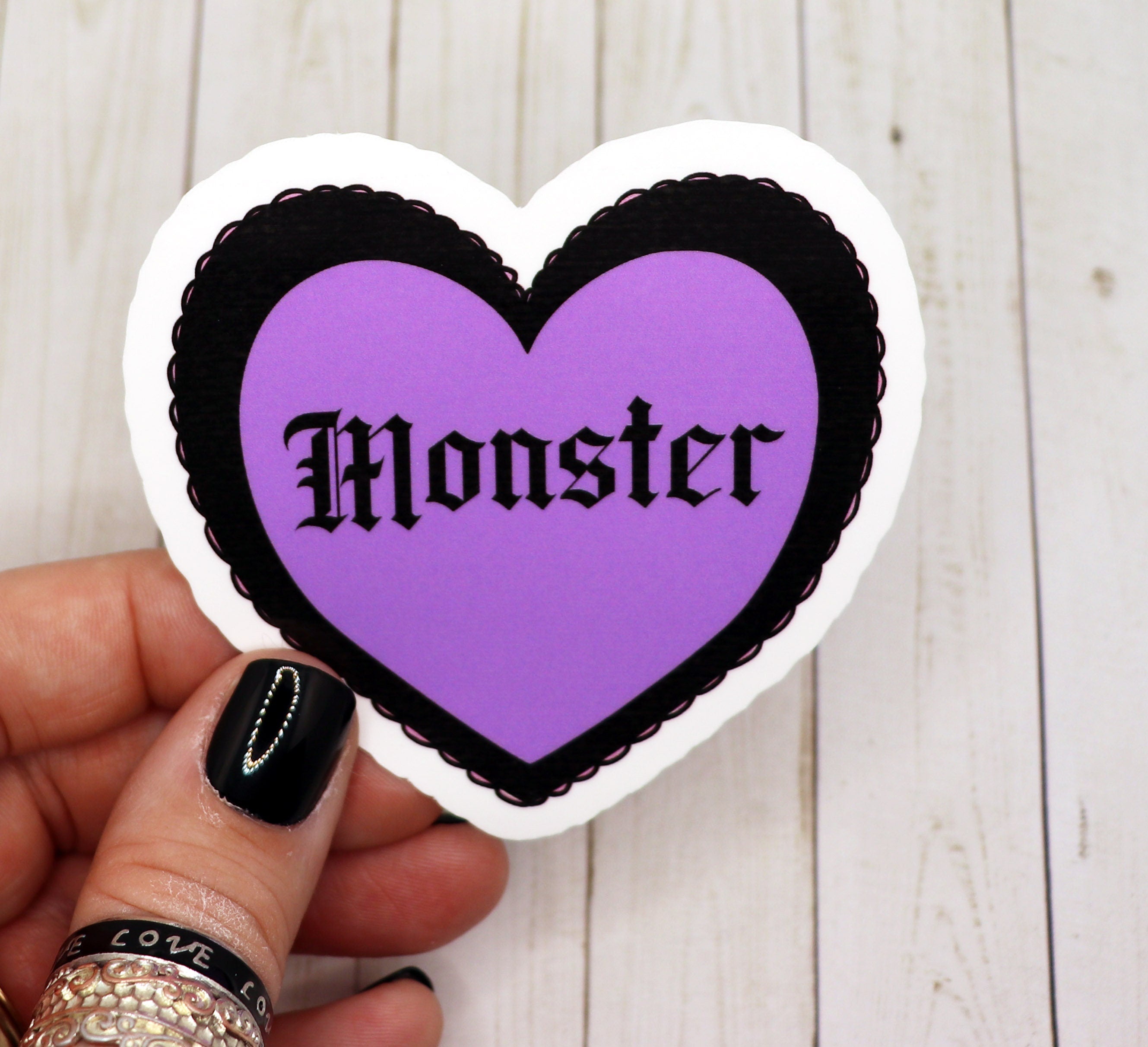 A pastel goth monster heart sticker featuring a cute monster design in pastel colors, perfect for personalizing items.