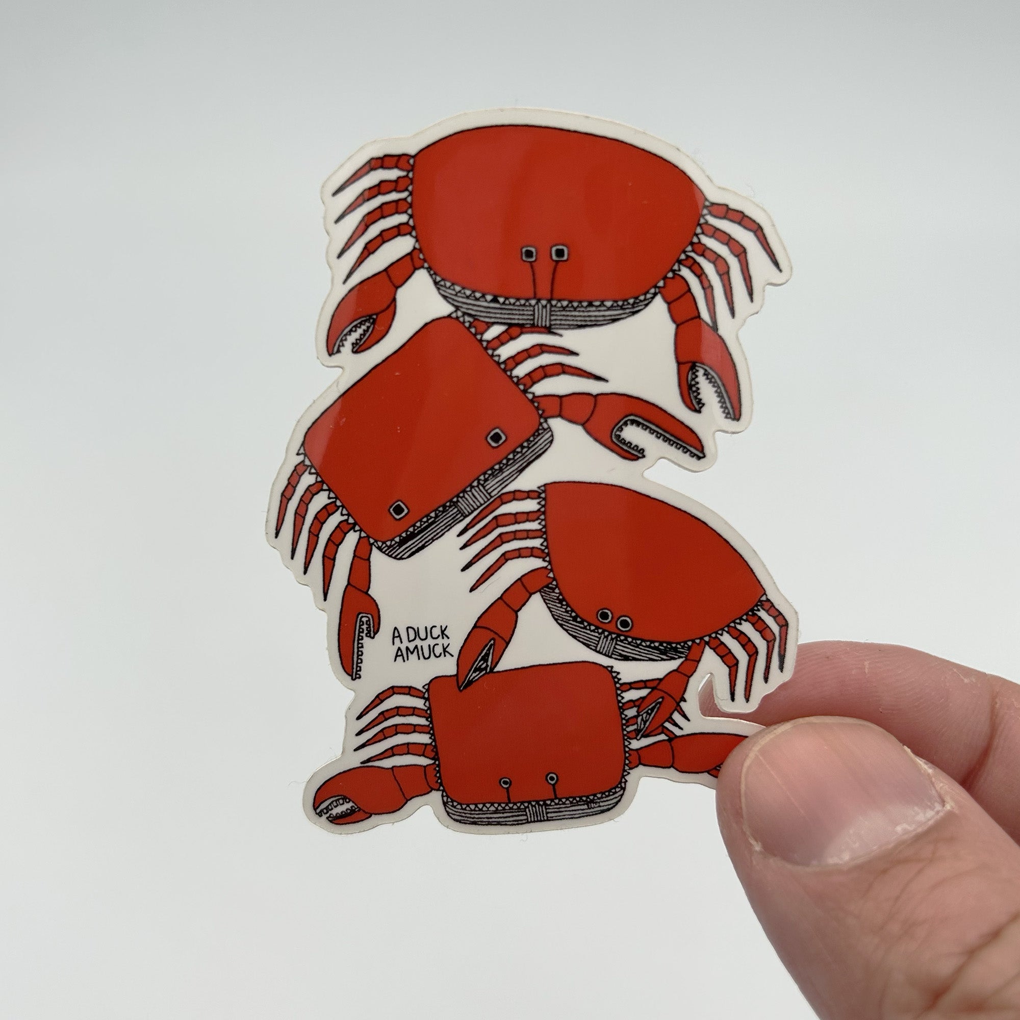 A colorful vinyl sticker featuring a pile of crabs, showcasing vibrant colors and a glossy finish, perfect for personalizing items.