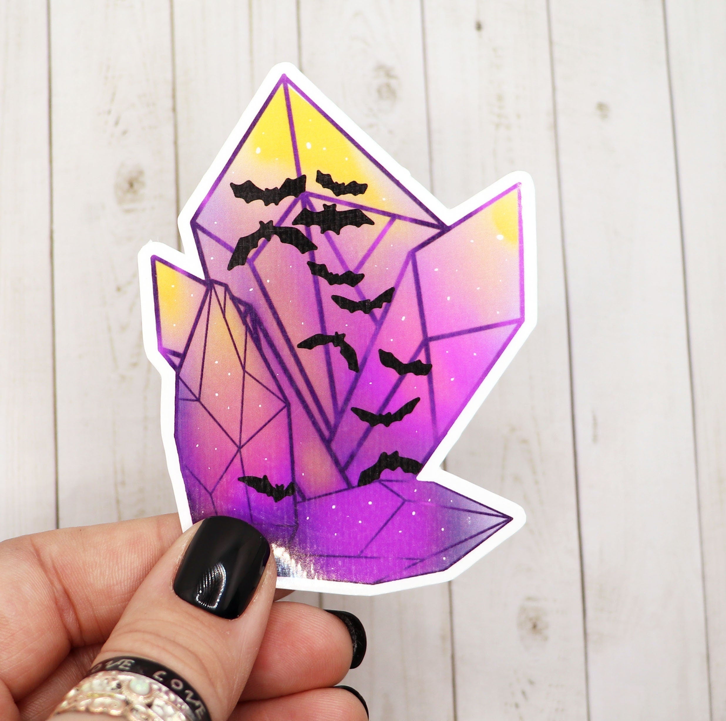 A vibrant purple bat crystal sticker on a matte vinyl surface, showcasing intricate details and a glossy finish.
