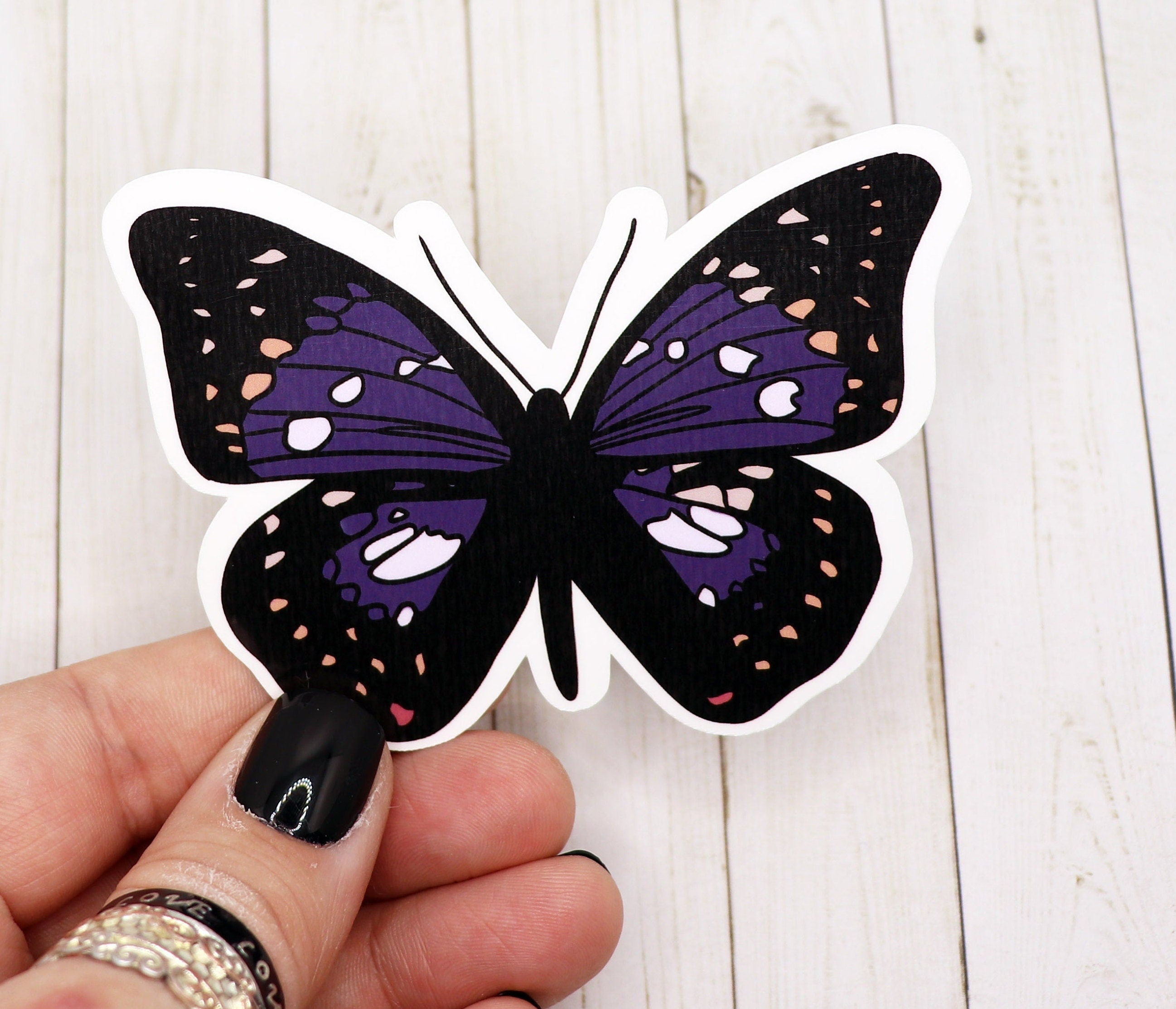 A vibrant purple butterfly sticker on a white background, showcasing its intricate design and matte finish.