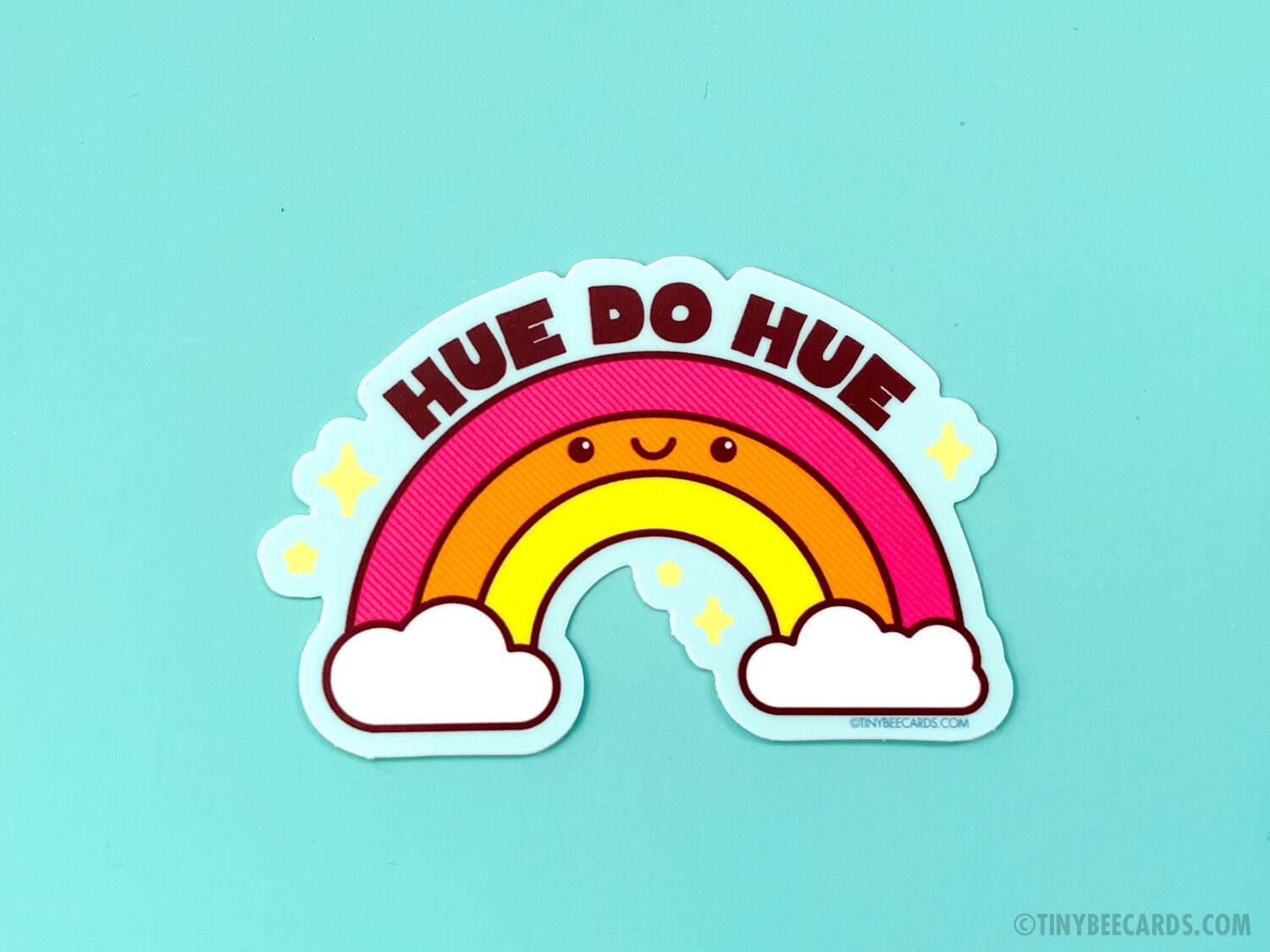 Colorful rainbow vinyl sticker with pun text 'Hue do hue!' on a sky blue background, perfect for personalizing items.
