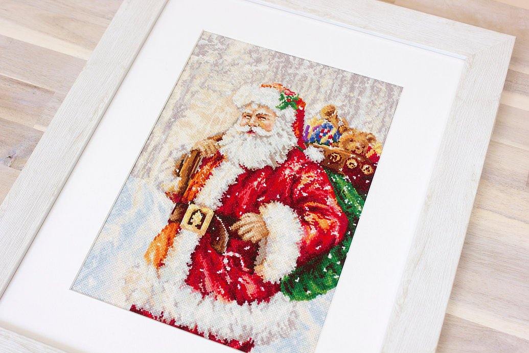 Santa Claus B575L Counted Cross-Stitch Kit featuring Santa with gifts in a winter landscape, includes Aida canvas and 45 colors.