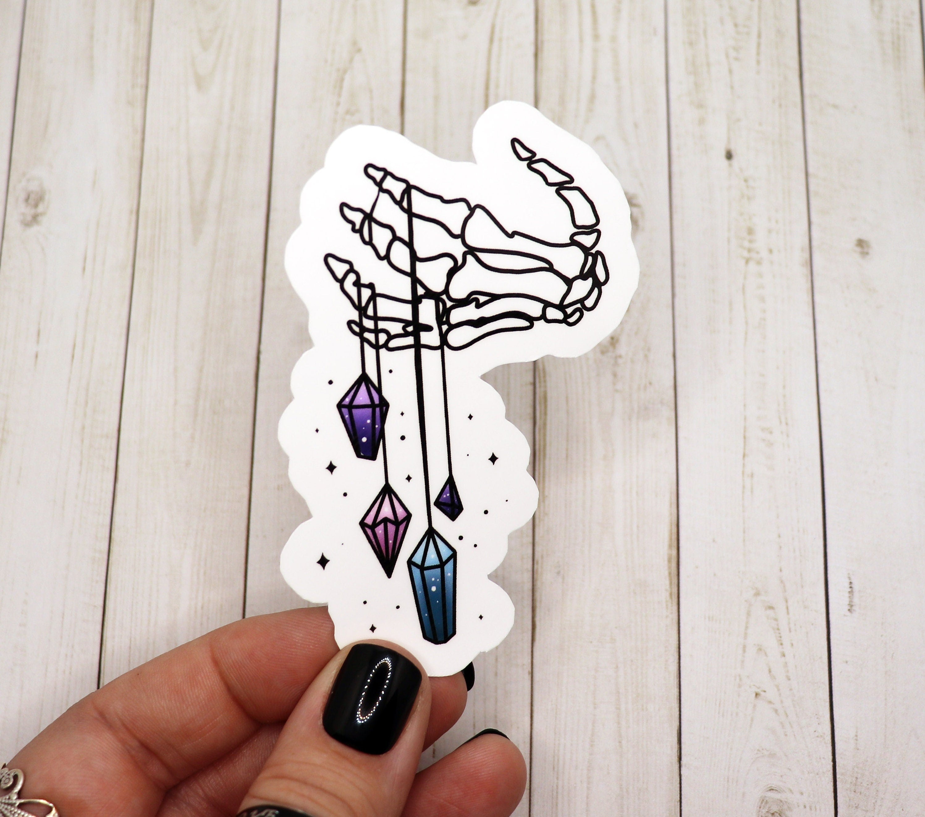 A vibrant skeleton hand sticker adorned with colorful crystals, printed on matte vinyl.