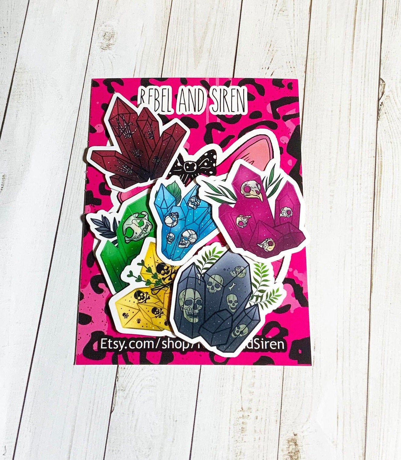 A pack of six skull crystal stickers on a white background, showcasing their vibrant colors and matte finish.