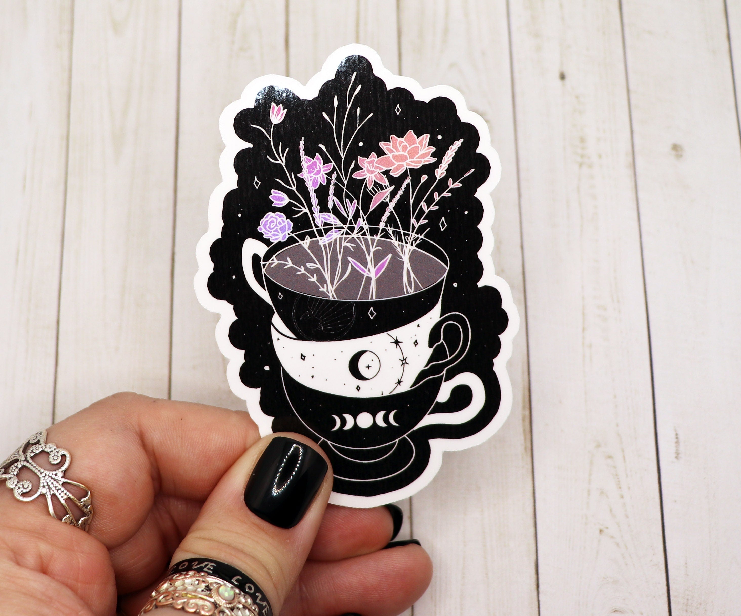 A colorful sticker featuring a stack of tea cups adorned with flowers, showcasing a whimsical design.