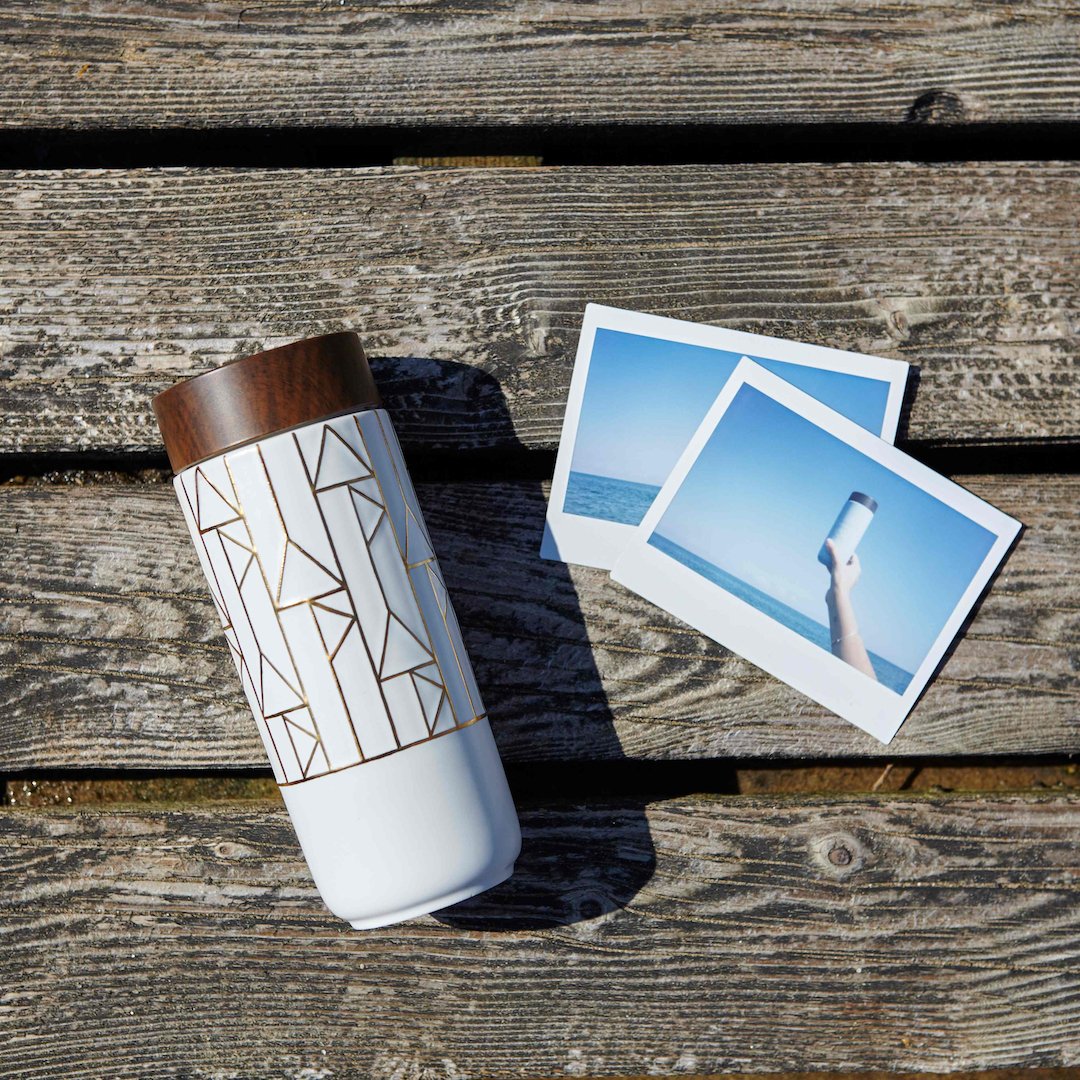 The Alchemical Signs Gold Ceramic Travel Mug featuring a vibrant gold hand-painted design with geometric patterns inspired by ancient alchemical symbols.