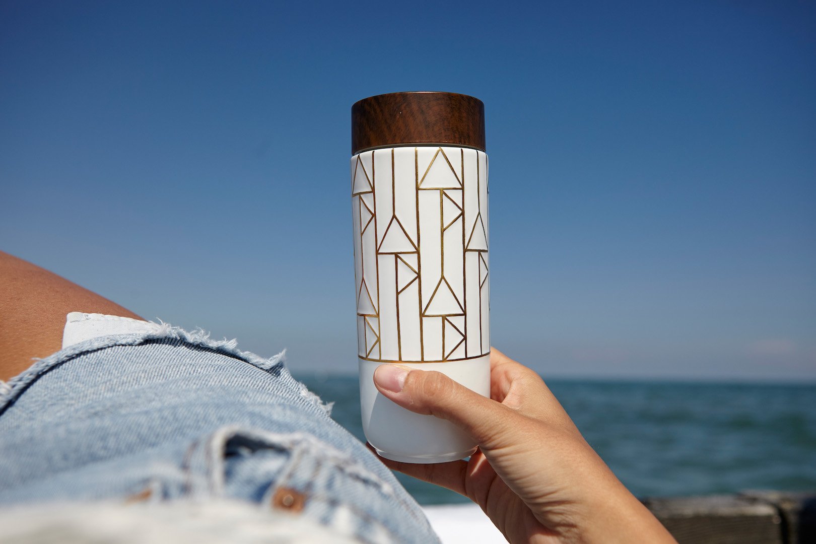 The Alchemical Signs Gold Ceramic Travel Mug featuring a vibrant gold hand-painted design with geometric patterns inspired by ancient alchemical symbols.