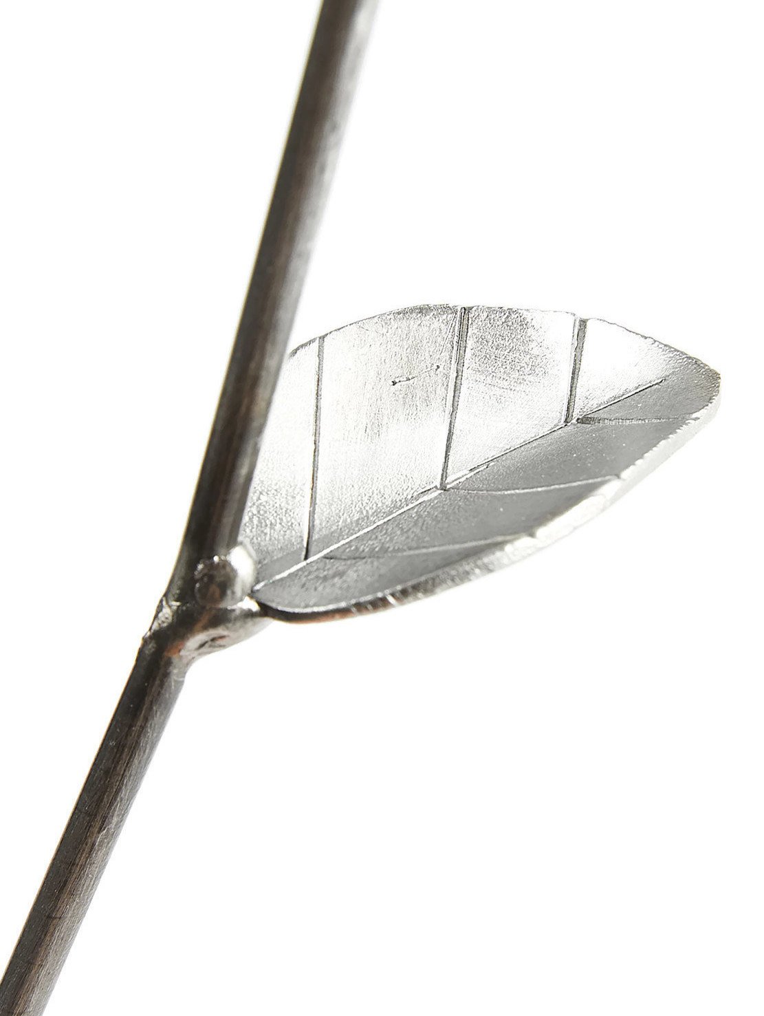 Three handcrafted metal roses in a rustic vase, made from recycled materials, showcasing unique welded designs and a shiny lacquer finish.