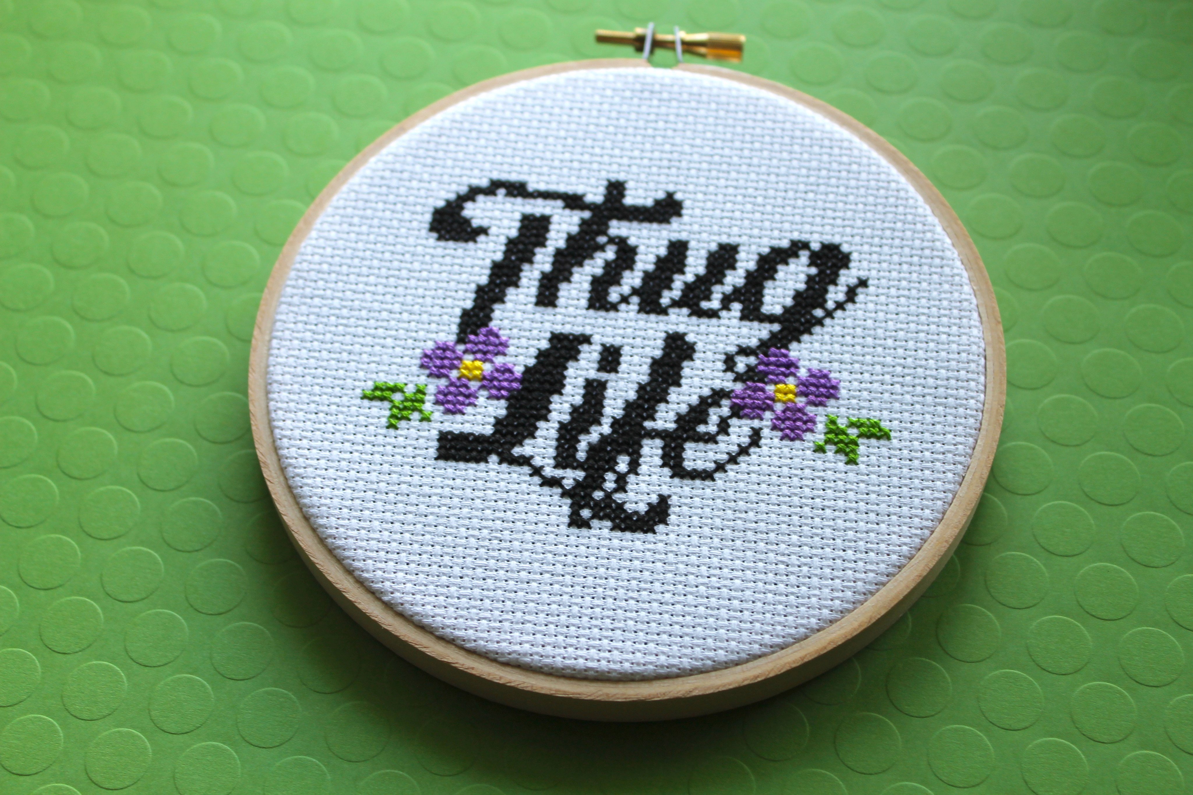 Thug Life Counted Cross Stitch DIY Kit featuring floral elements and cursive lettering.