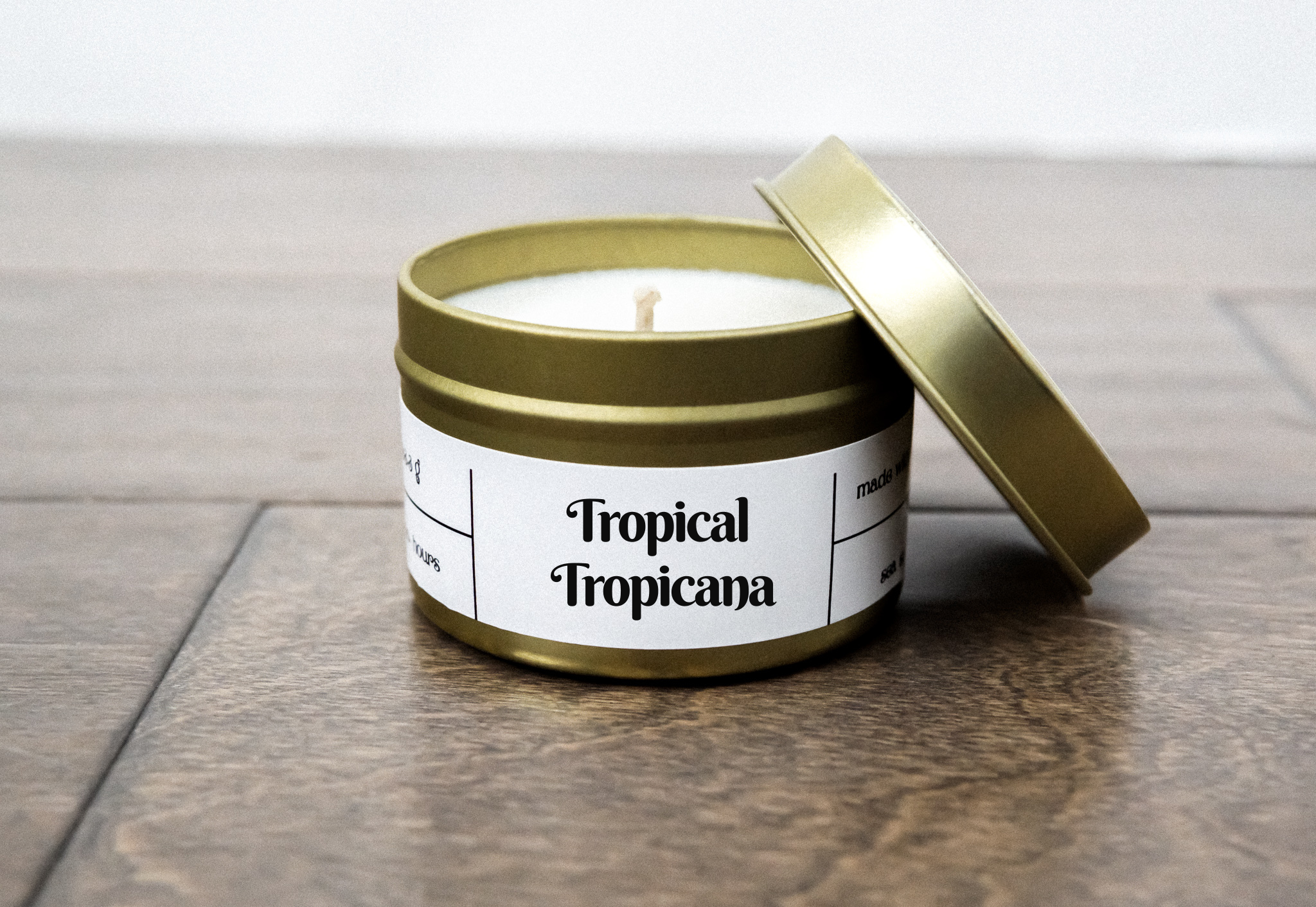 Tropical Tropicana Gold Travel Candle in a gold tin jar, featuring a blend of peach, mango, pineapple, and coconut milk scents.