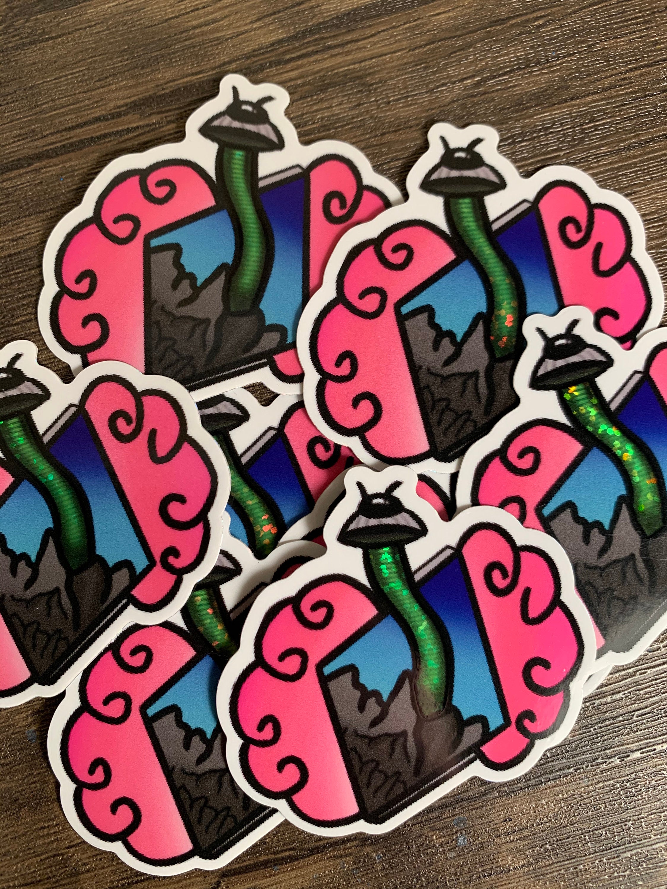 A colorful UFO glitter holographic sticker featuring a whimsical design, perfect for personalizing items like laptops and water bottles.