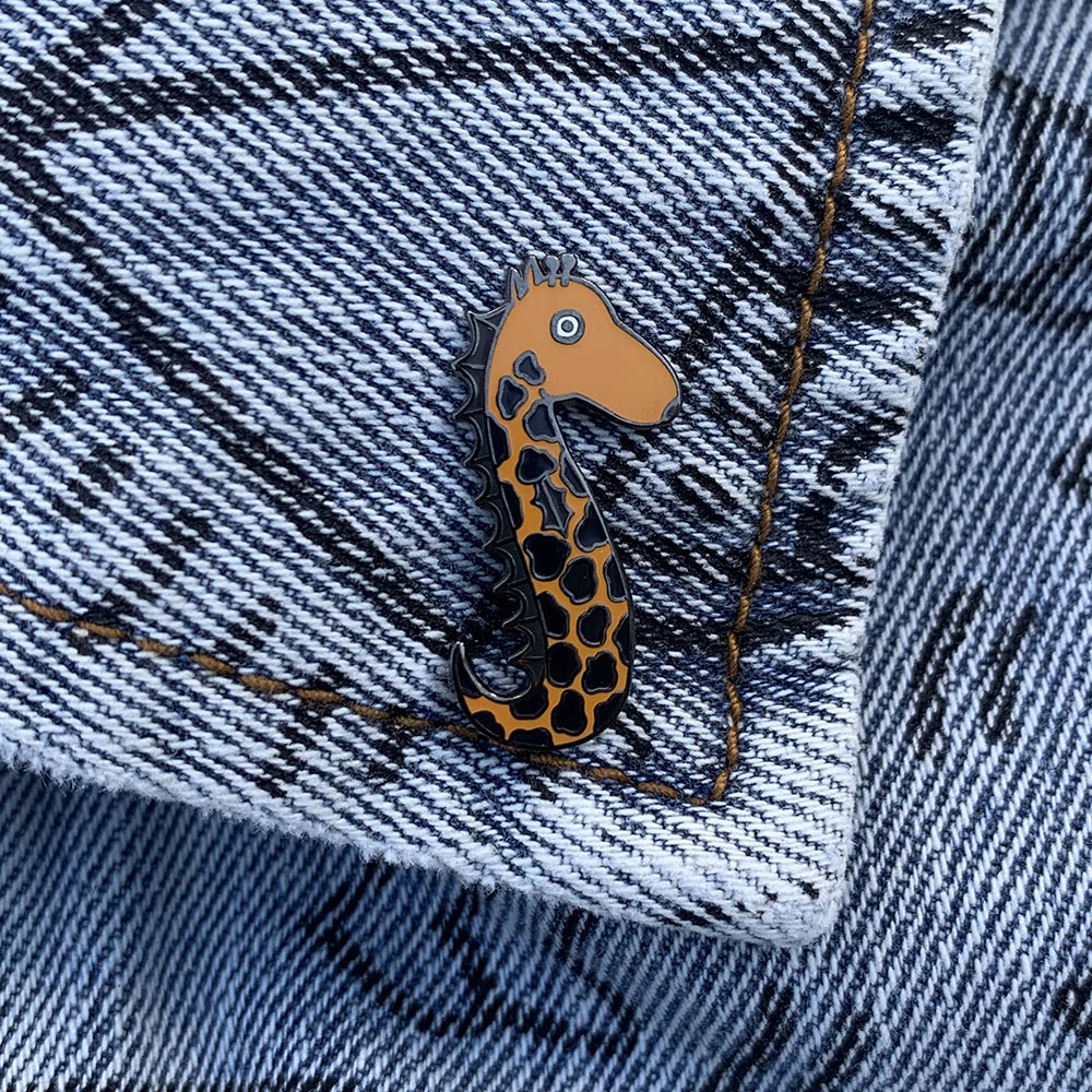 Vinny the Seahorse Giraffe enamel pin featuring a whimsical design with vibrant colors and a nickel-plated metal backing.