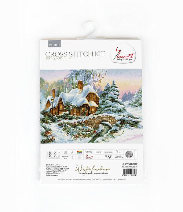 Winter landscape counted cross-stitch kit featuring Aida canvas, vibrant threads, and a needle for crafting.