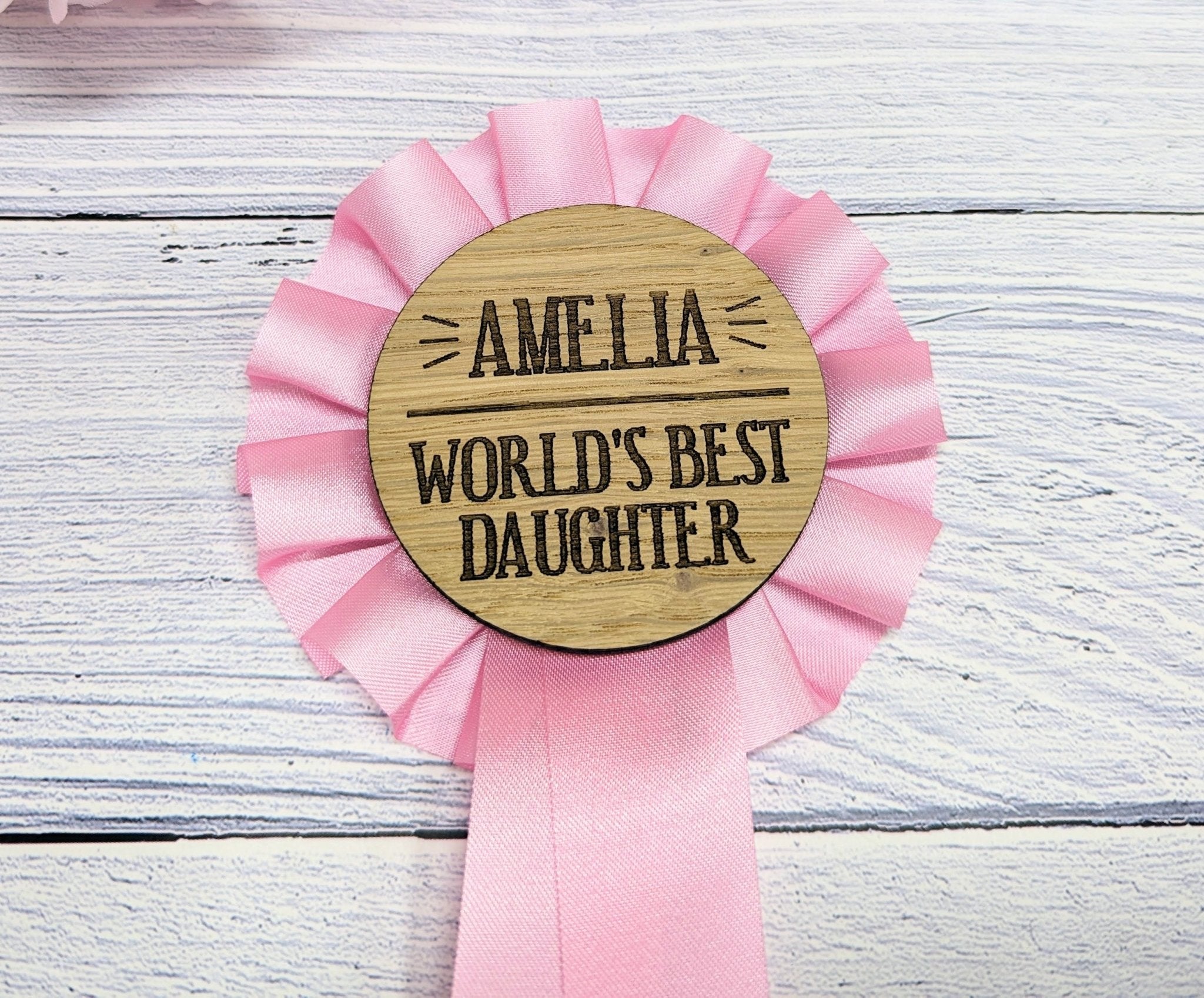 Personalised wooden rosette in vibrant pink, celebrating the world's best daughter, handcrafted from oak veneered MDF.