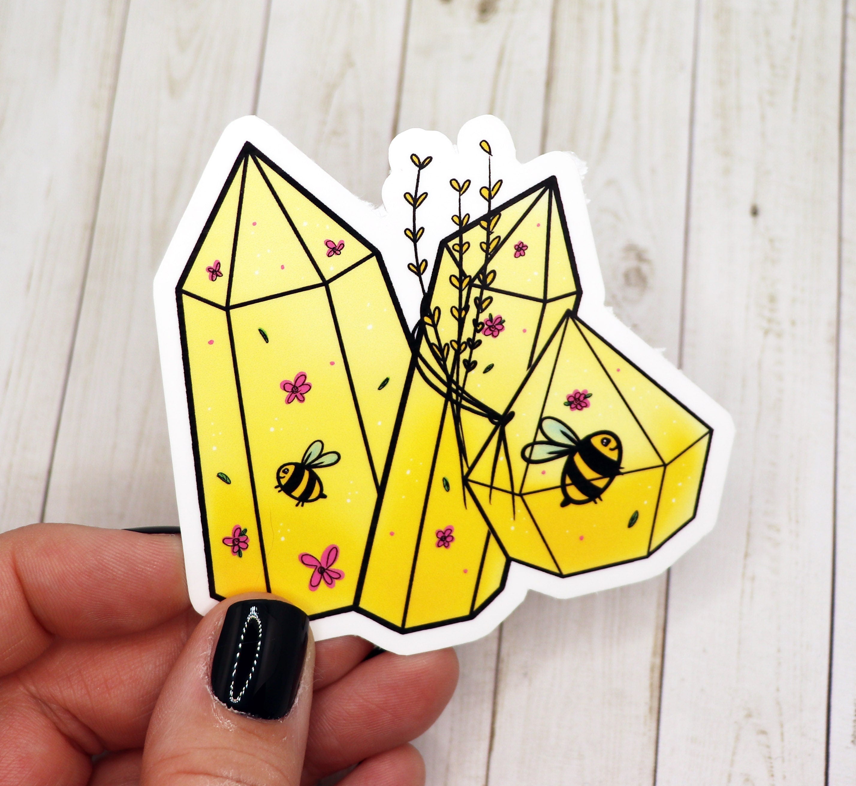 A vibrant yellow bee crystal sticker on a matte vinyl background, showcasing its intricate design and glossy finish.