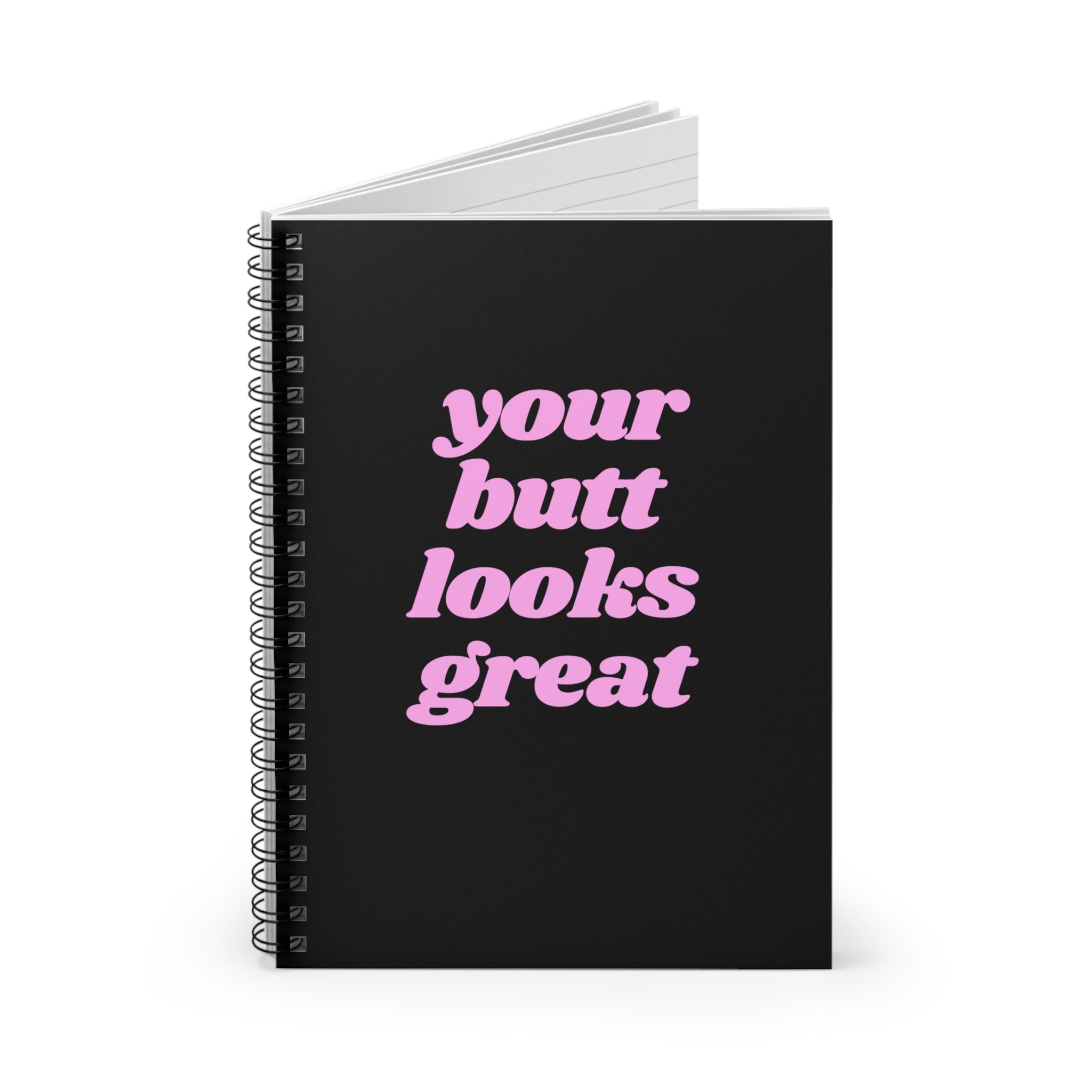 A spiral notebook with a humorous front cover saying 'Your Butt Looks Great', featuring ruled line pages and a dark grey back cover.