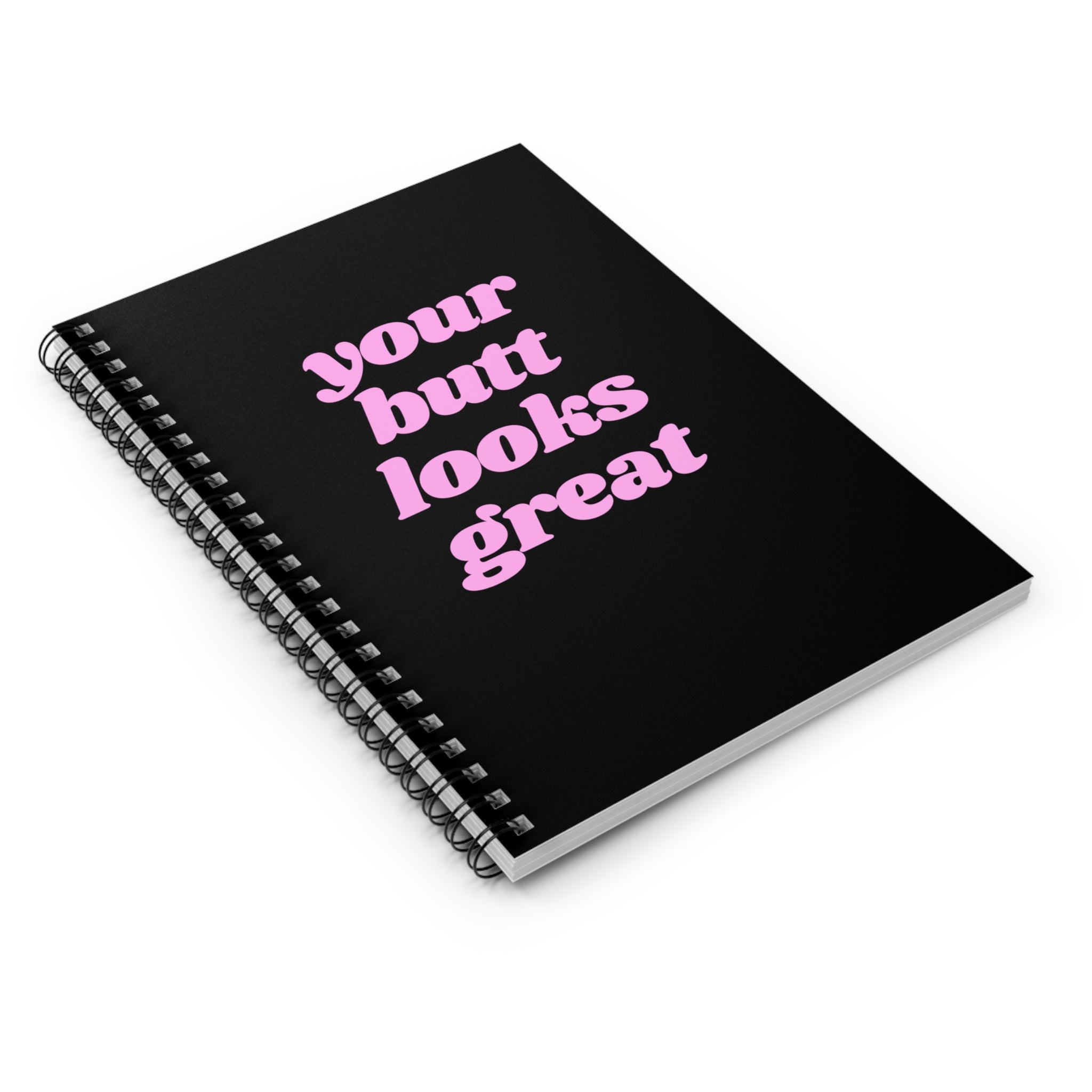 A spiral notebook with a humorous front cover saying 'Your Butt Looks Great', featuring ruled line pages and a dark grey back cover.