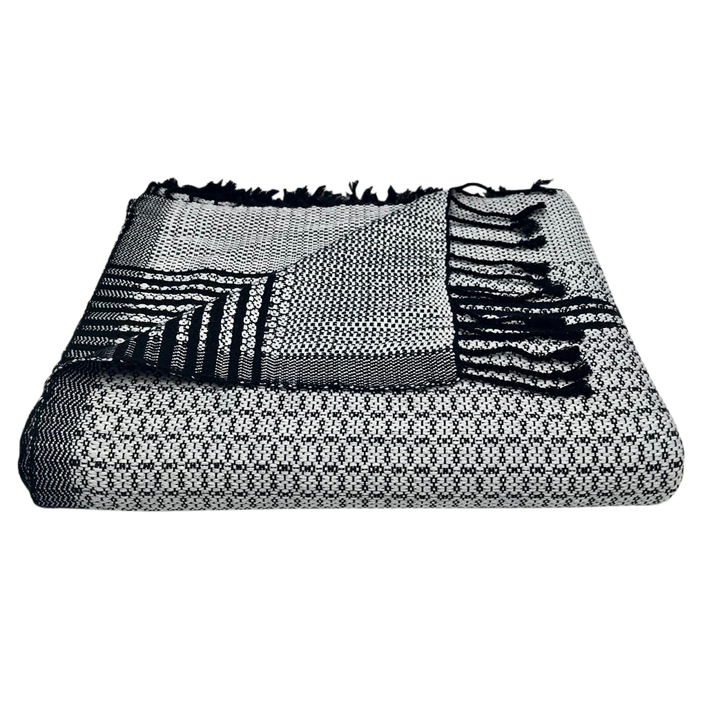 A luxurious silver gray and black tapestry throw made from organic cotton, featuring intricate flower patterns and hand-knotted fringe ends.