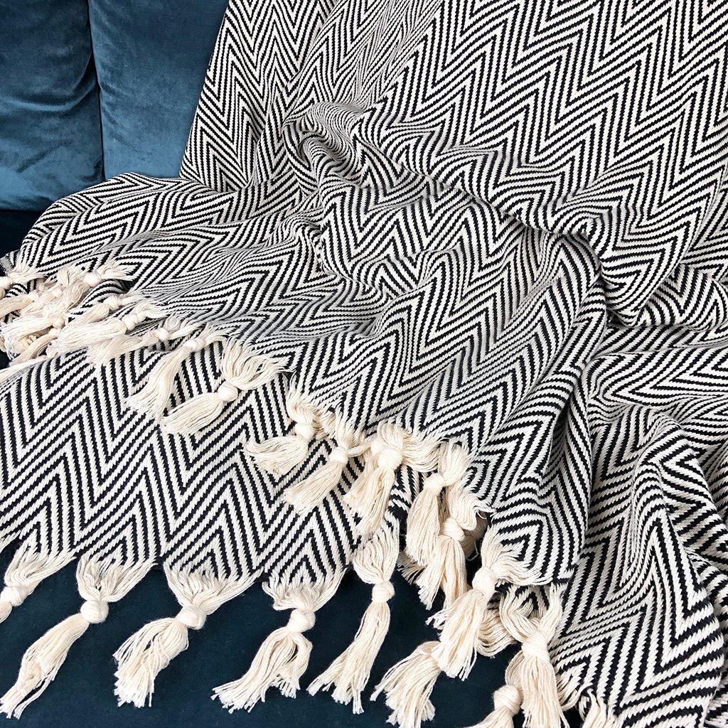 A cozy Chunky Chevron Turkish Throw featuring an intricate chevron pattern and hand-knotted fringe, perfect for home decor.