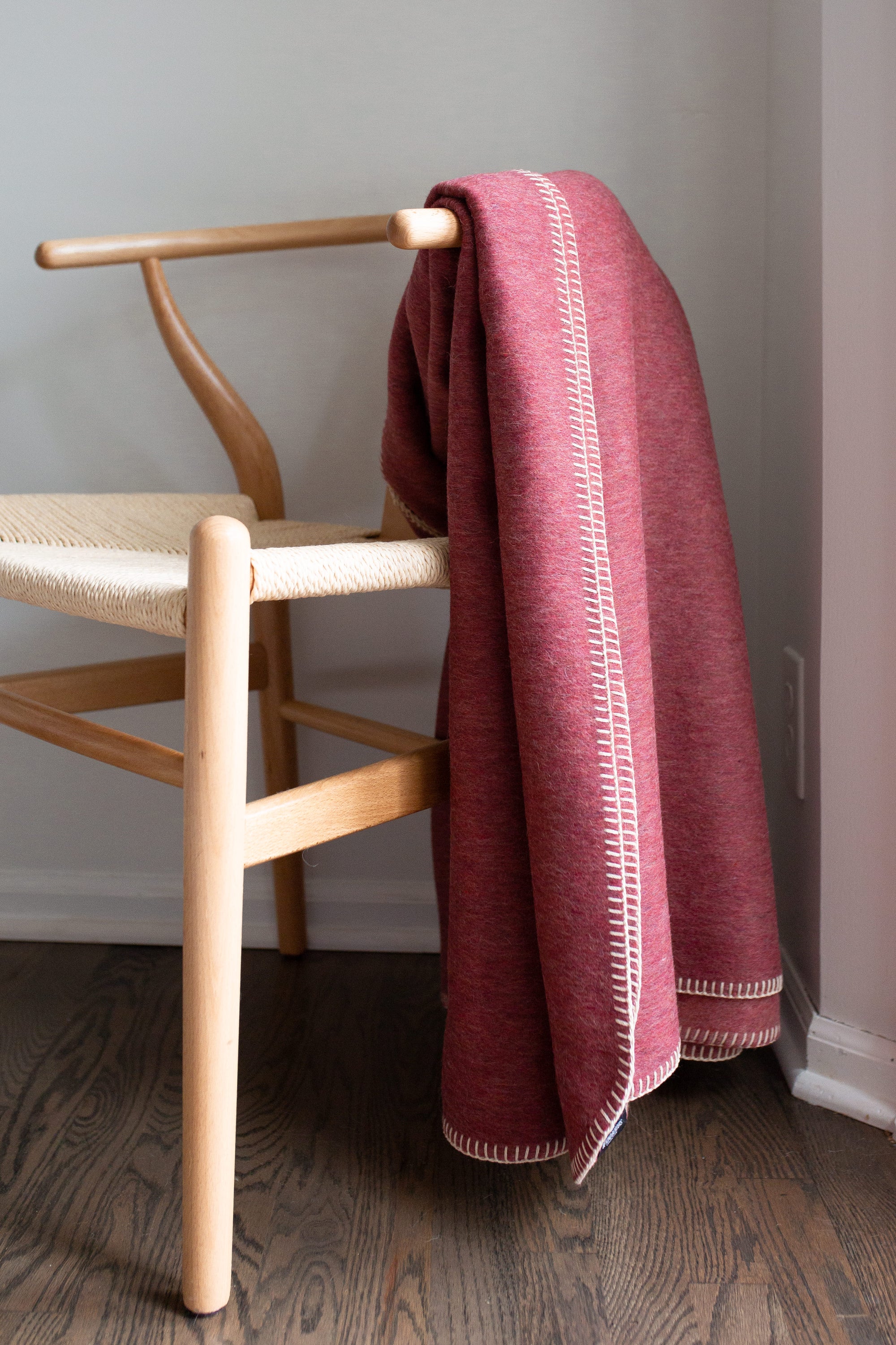 Descanso Alpaca Blend Throw in Dusty Red, showcasing its soft texture and elegant design, perfect for home decor.