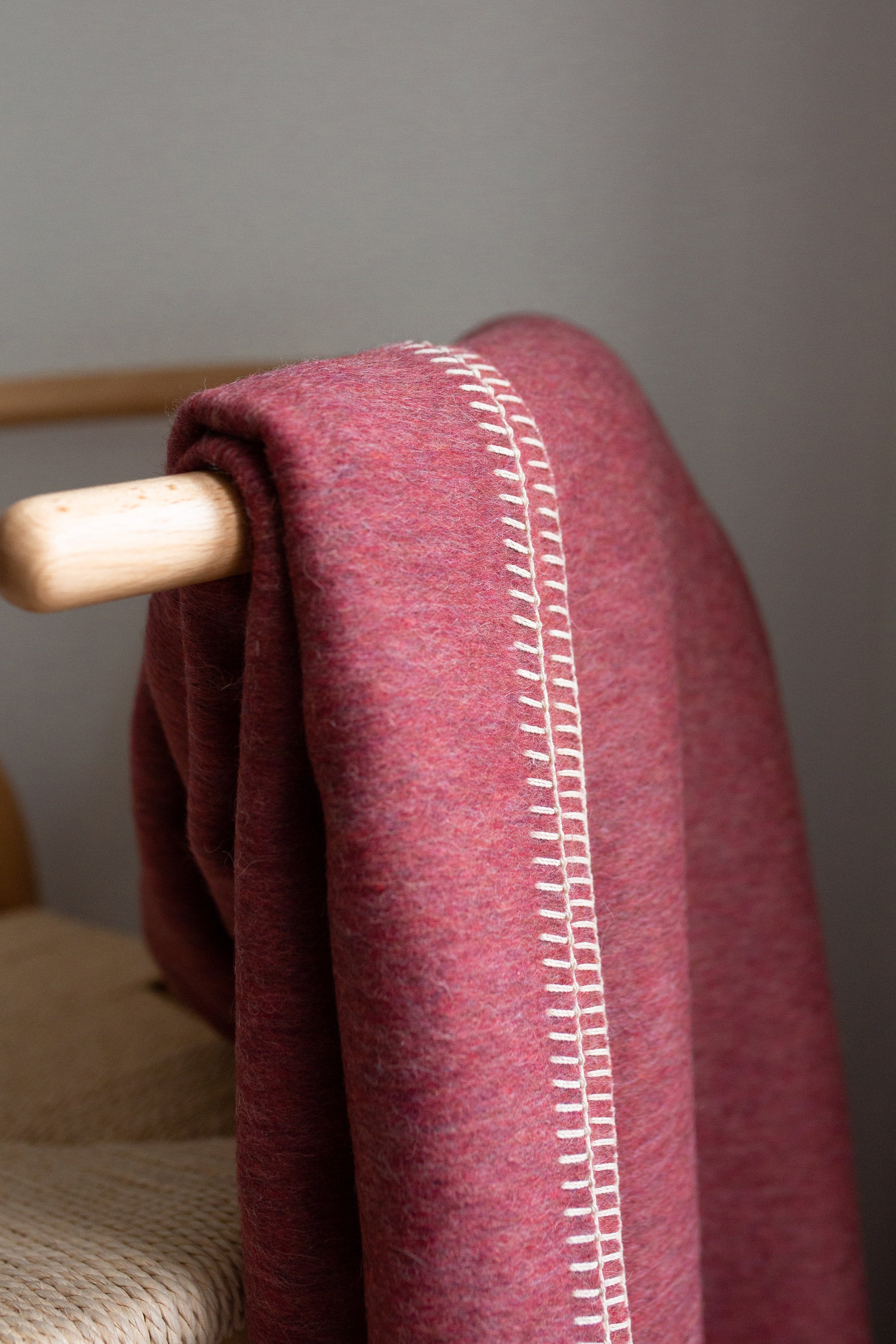 Descanso Alpaca Blend Throw in Dusty Red, showcasing its soft texture and elegant design, perfect for home decor.