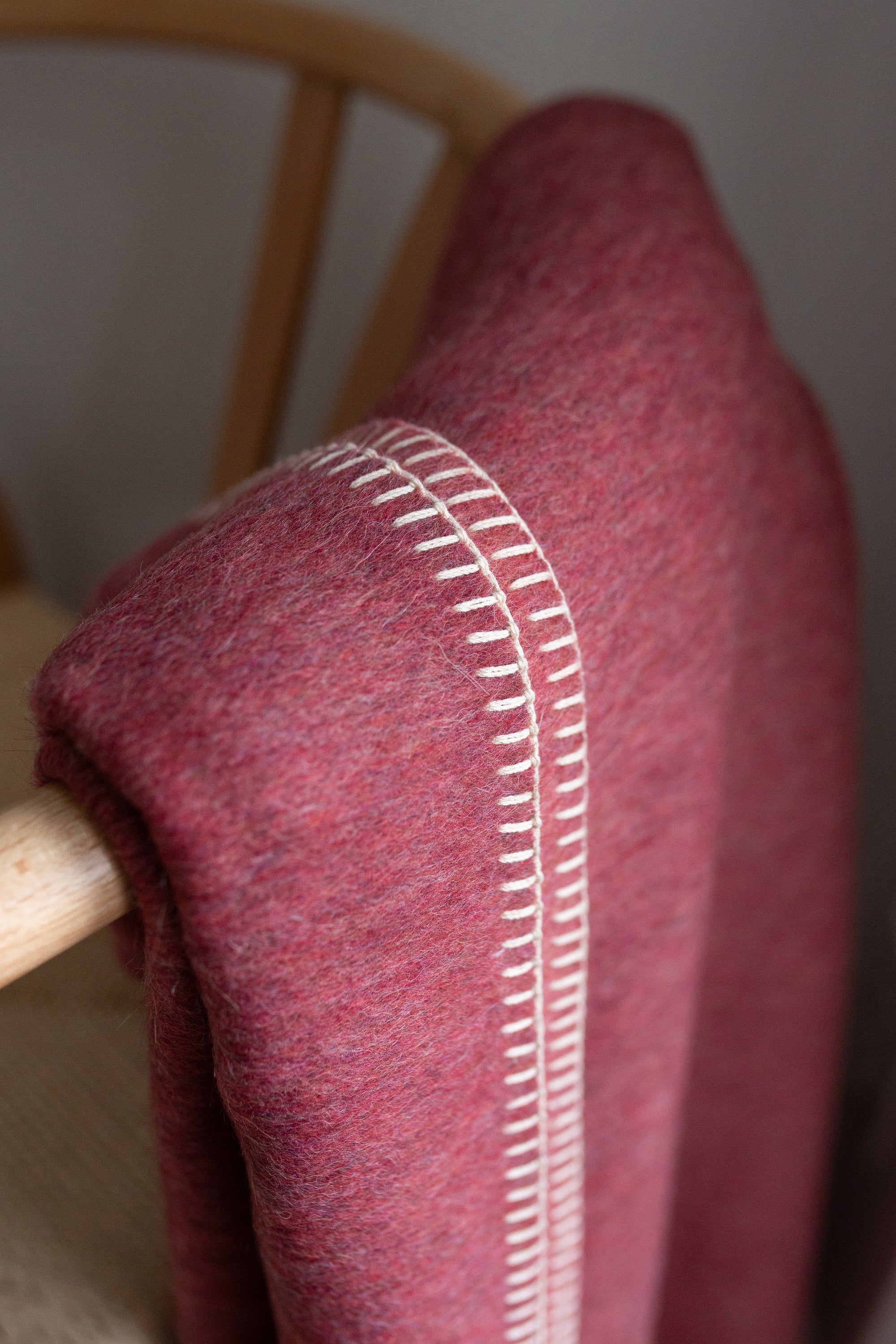 Descanso Alpaca Blend Throw in Dusty Red, showcasing its soft texture and elegant design, perfect for home decor.