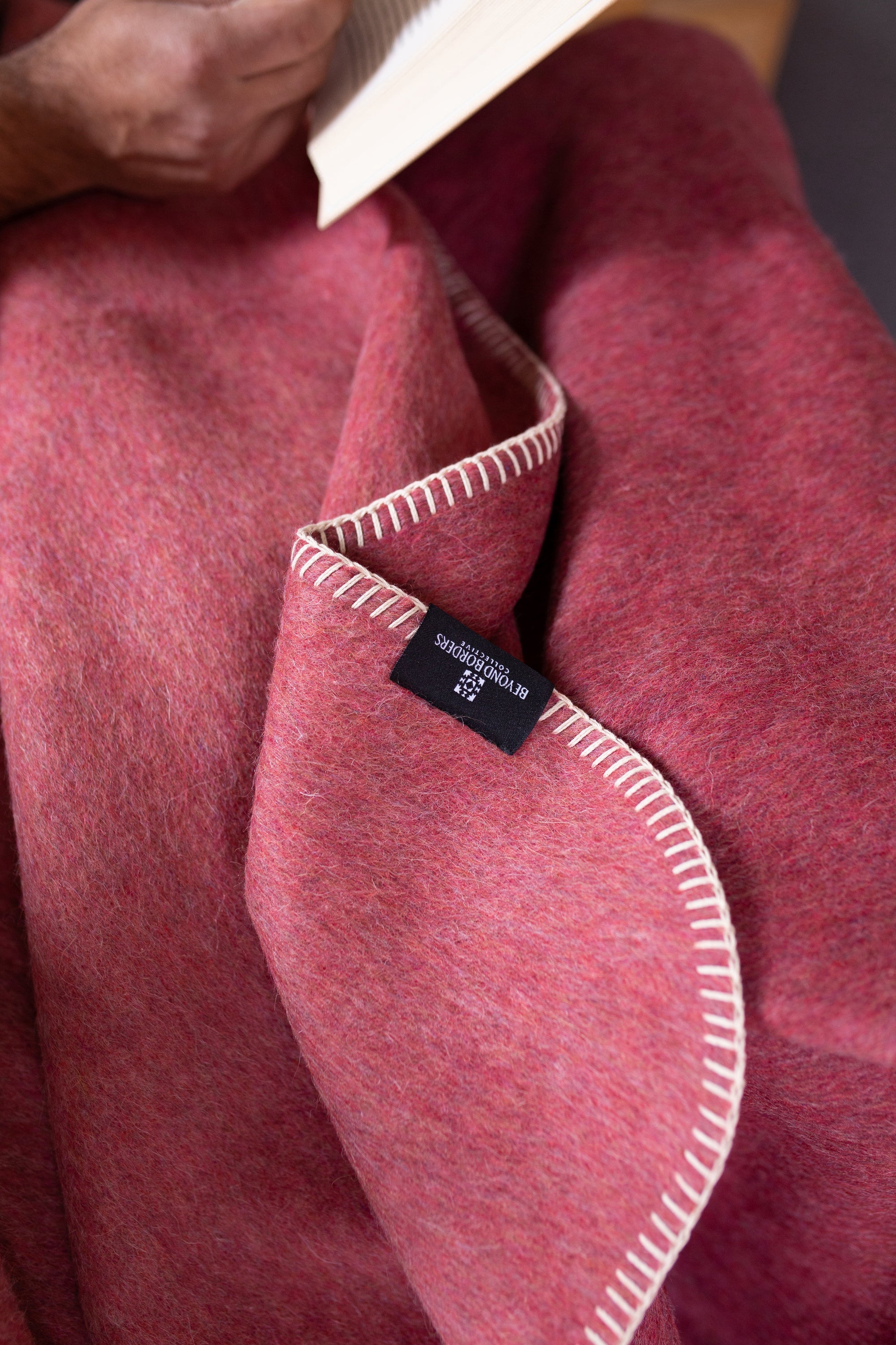 Descanso Alpaca Blend Throw in Dusty Red, showcasing its soft texture and elegant design, perfect for home decor.