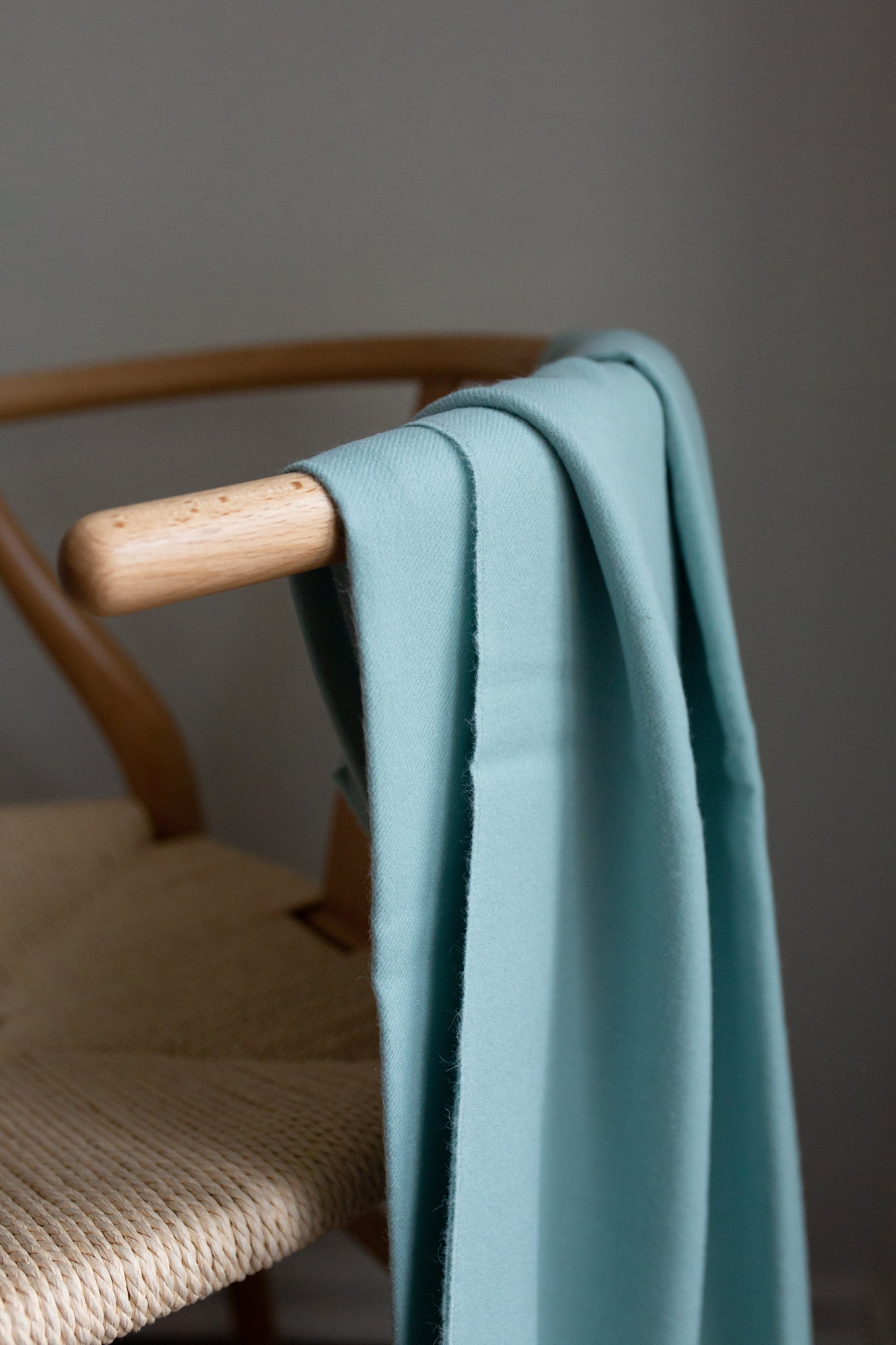 Esencia Alpaca Throw in Sky Blue, showcasing its soft texture and elegant design, perfect for home decor.