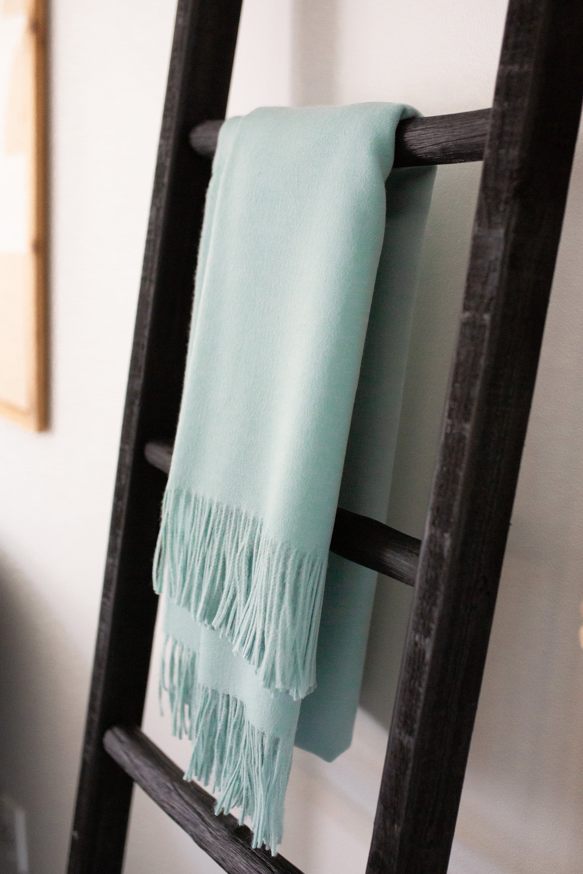 Esencia Alpaca Throw in Sky Blue, showcasing its soft texture and elegant design, perfect for home decor.