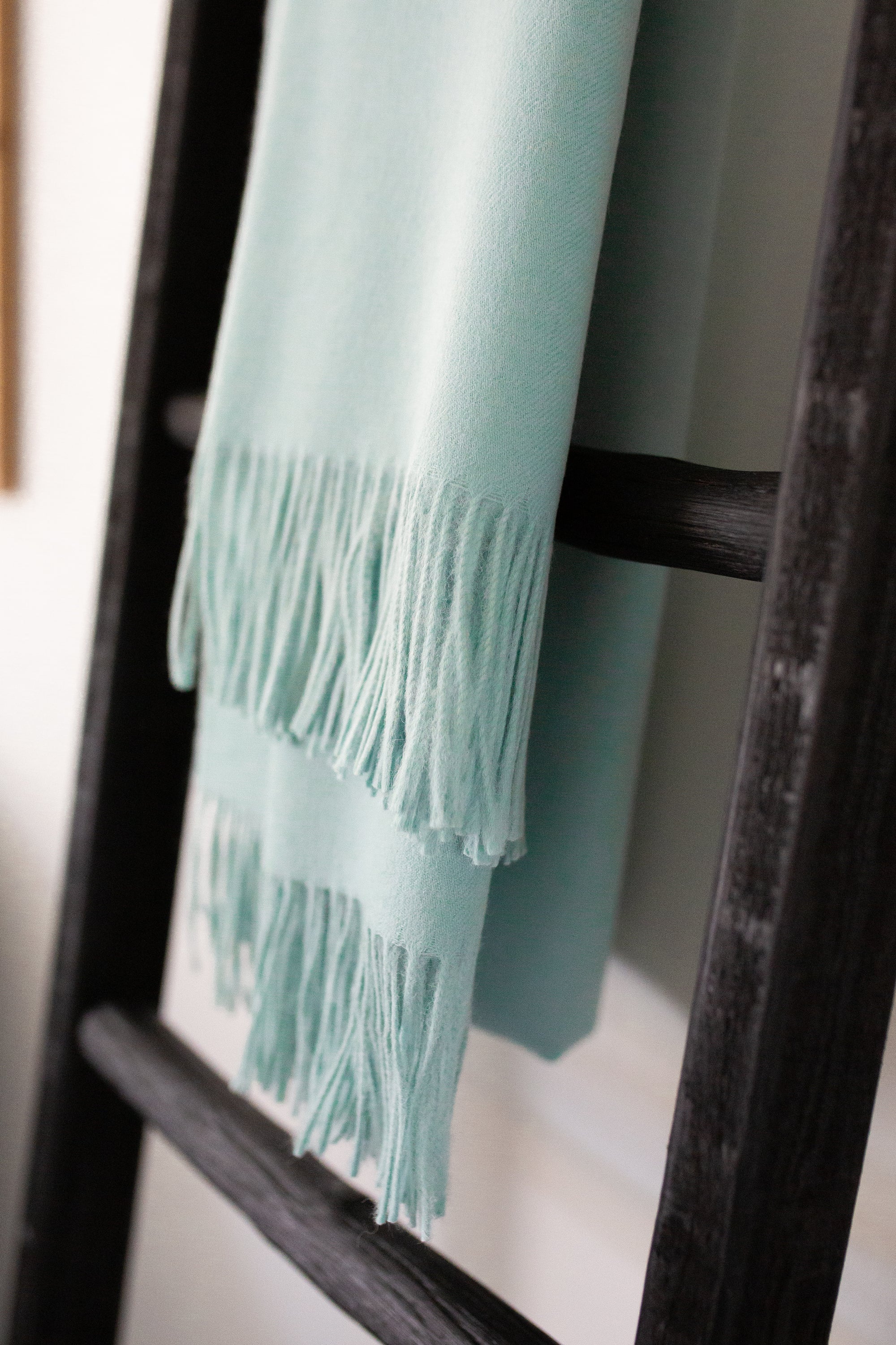 Esencia Alpaca Throw in Sky Blue, showcasing its soft texture and elegant design, perfect for home decor.
