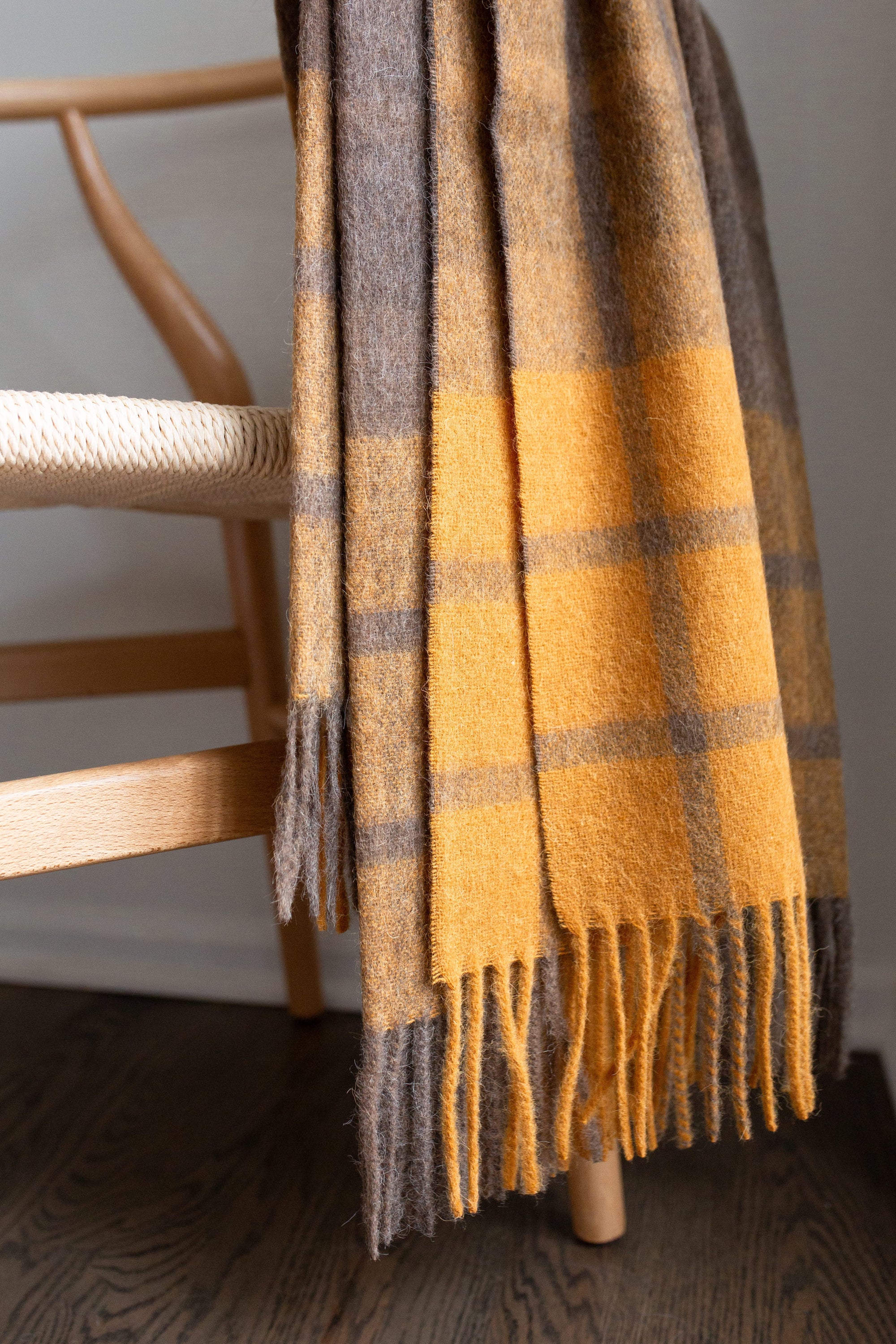 Estancia Alpaca Blend Throw in Grey and Mustard Yellow, showcasing its soft texture and elegant design.