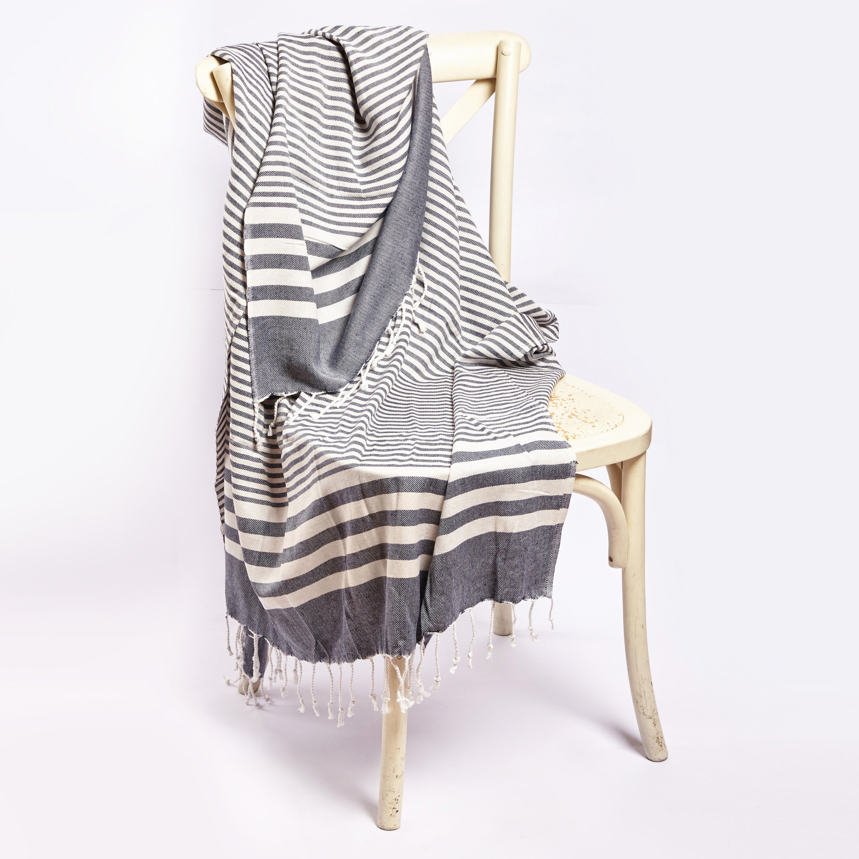 Fethiye Striped Blanket Throw in Blue with navy stripes, showcasing its soft texture and compact design, perfect for indoor and outdoor use.