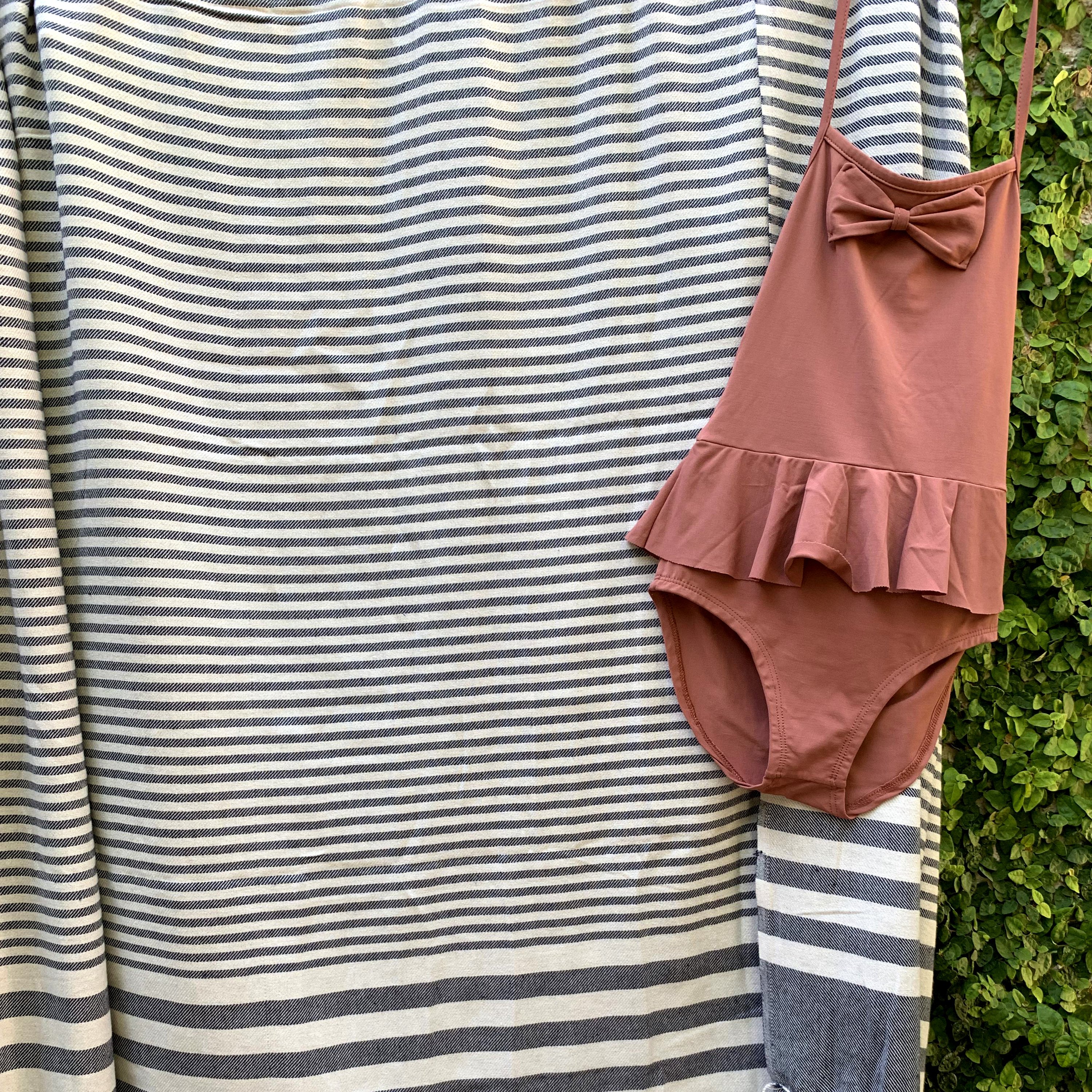 Fethiye Striped Blanket Throw in Blue with navy stripes, showcasing its soft texture and compact design, perfect for indoor and outdoor use.