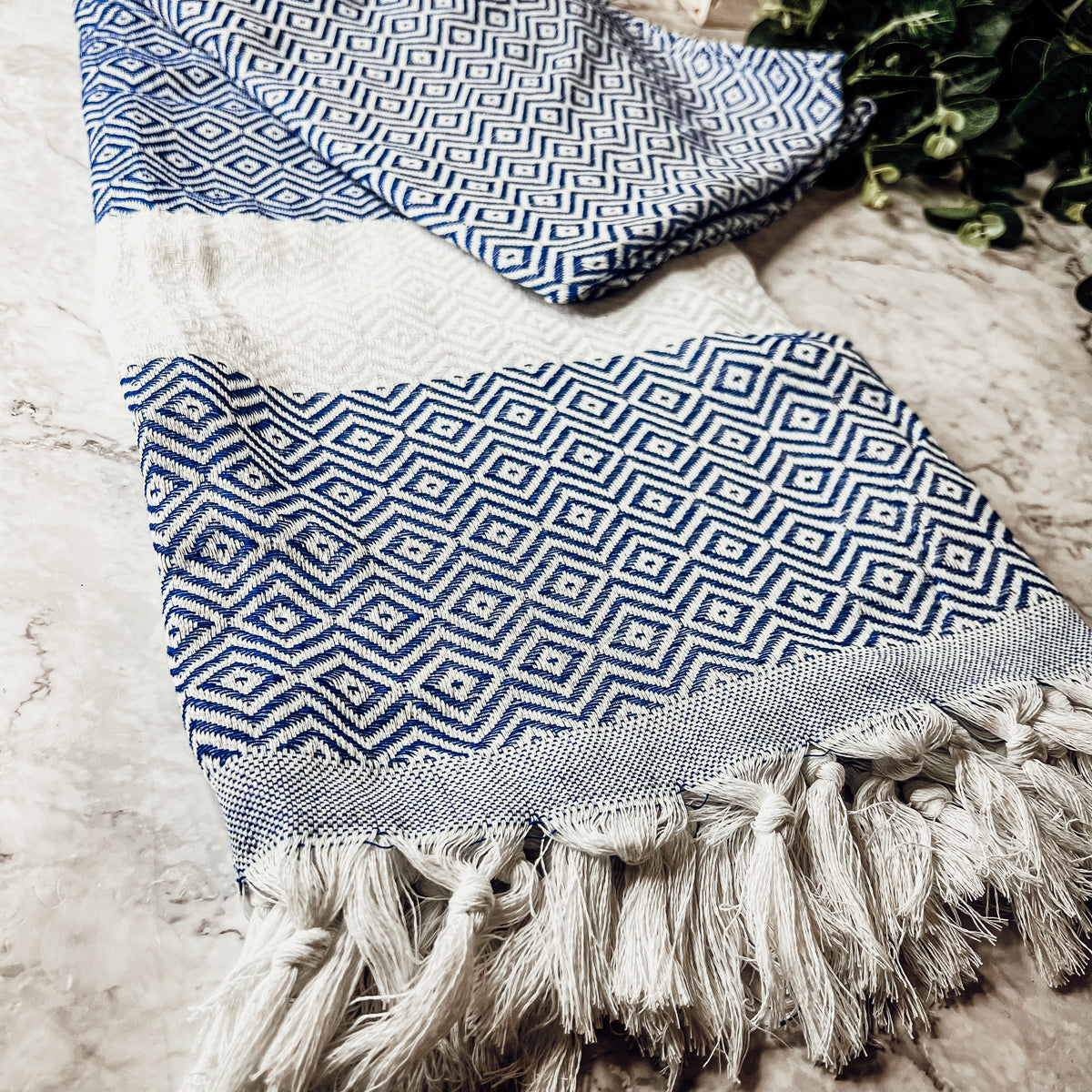 Haley Diamond Towel in blue with decorative tassels, showcasing its oversized design and soft texture.